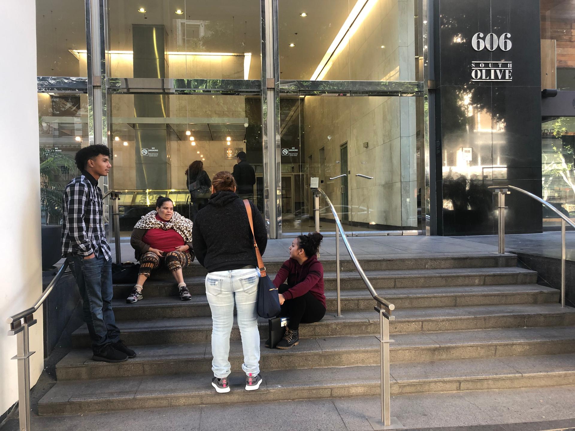 People sit on the steps outside Los Angeles immigration court, which has been closed since Dec. 22 due to a partial government shutdown over funding for a southern border wall. 