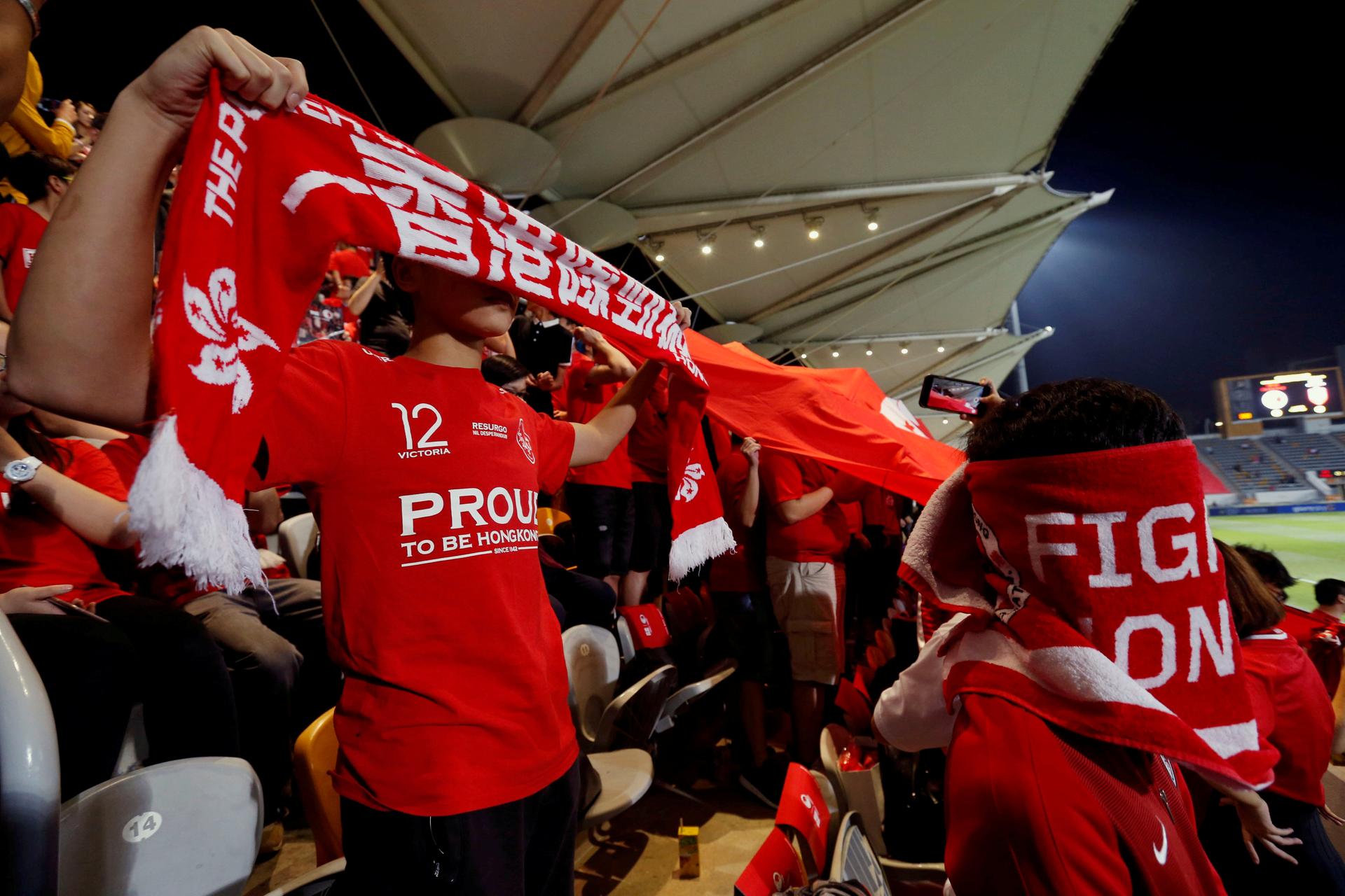 Hong Kong fans cover their faces and boo during the Chinese national anthem, at a friendly soccer match between Hong Kong and Bahrain in Hong Kong, China, November 9, 2017. 