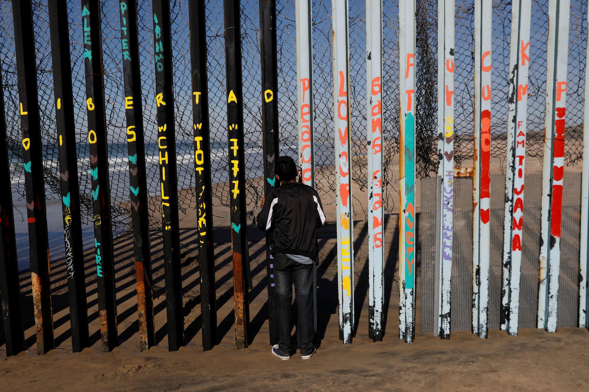 A boy looks through the slats of the US-Mexico border fence at Friendship Park in Tijuana, Mexico.