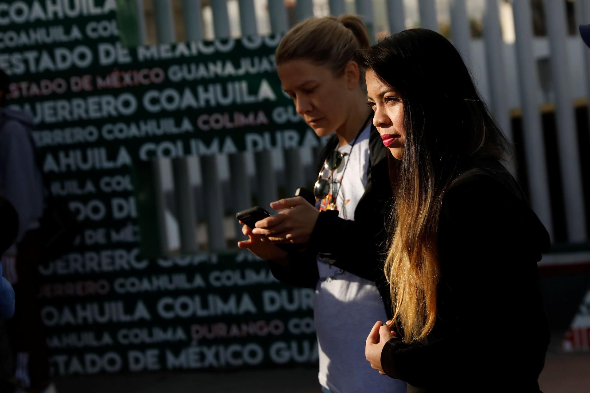 Two women wait at the Chaparral border crossing in Tijuana, Mexico.