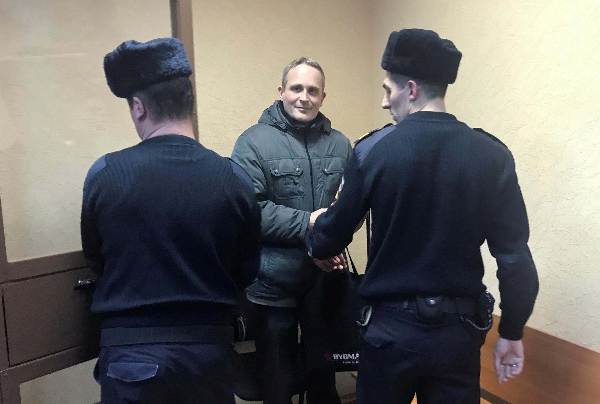 A Danish man seen with two Russian police in an office. 