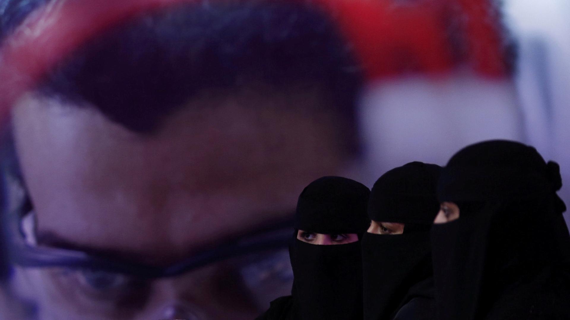 Three women in Saudi Arabia wearing black.
