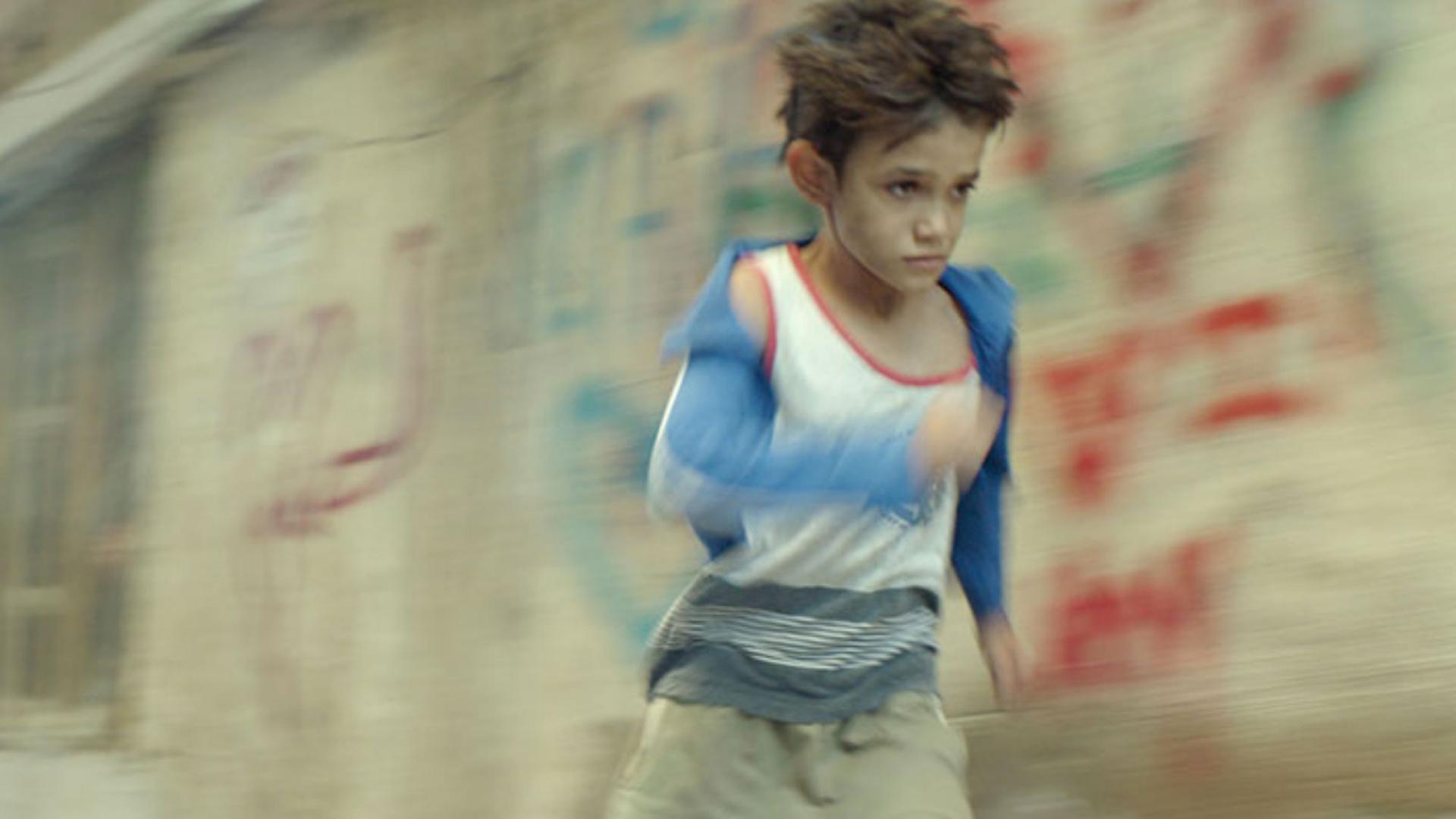 A boy in a blur running. 
