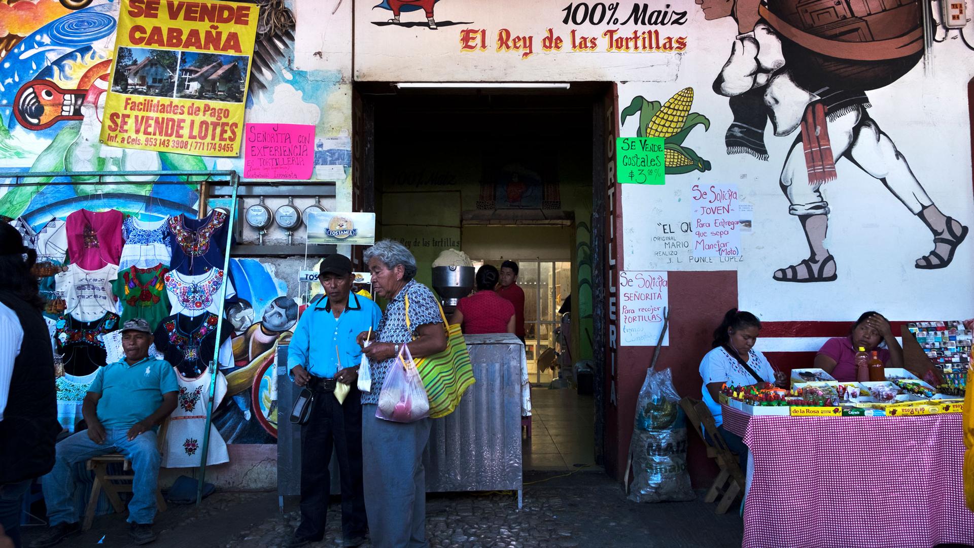 A market is shown in Tlaxiaco, Mexico, with vendors and shoppers.