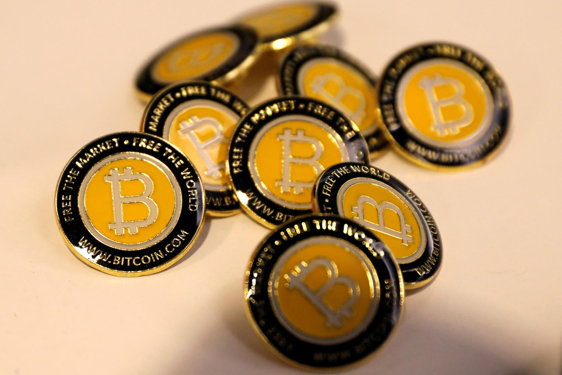 about a dozen bitcoin buttons in a pile