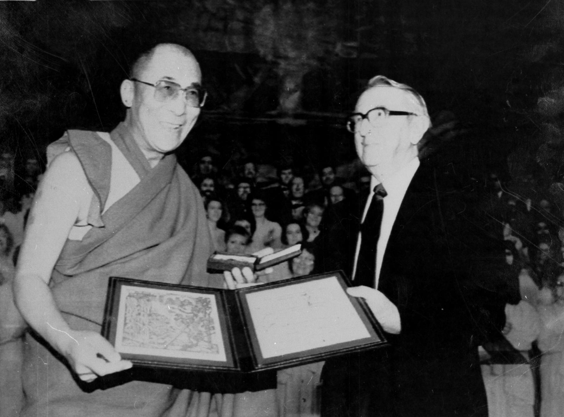 The Dalai Lama holds the Nobel Peace prize in a black and white photograph