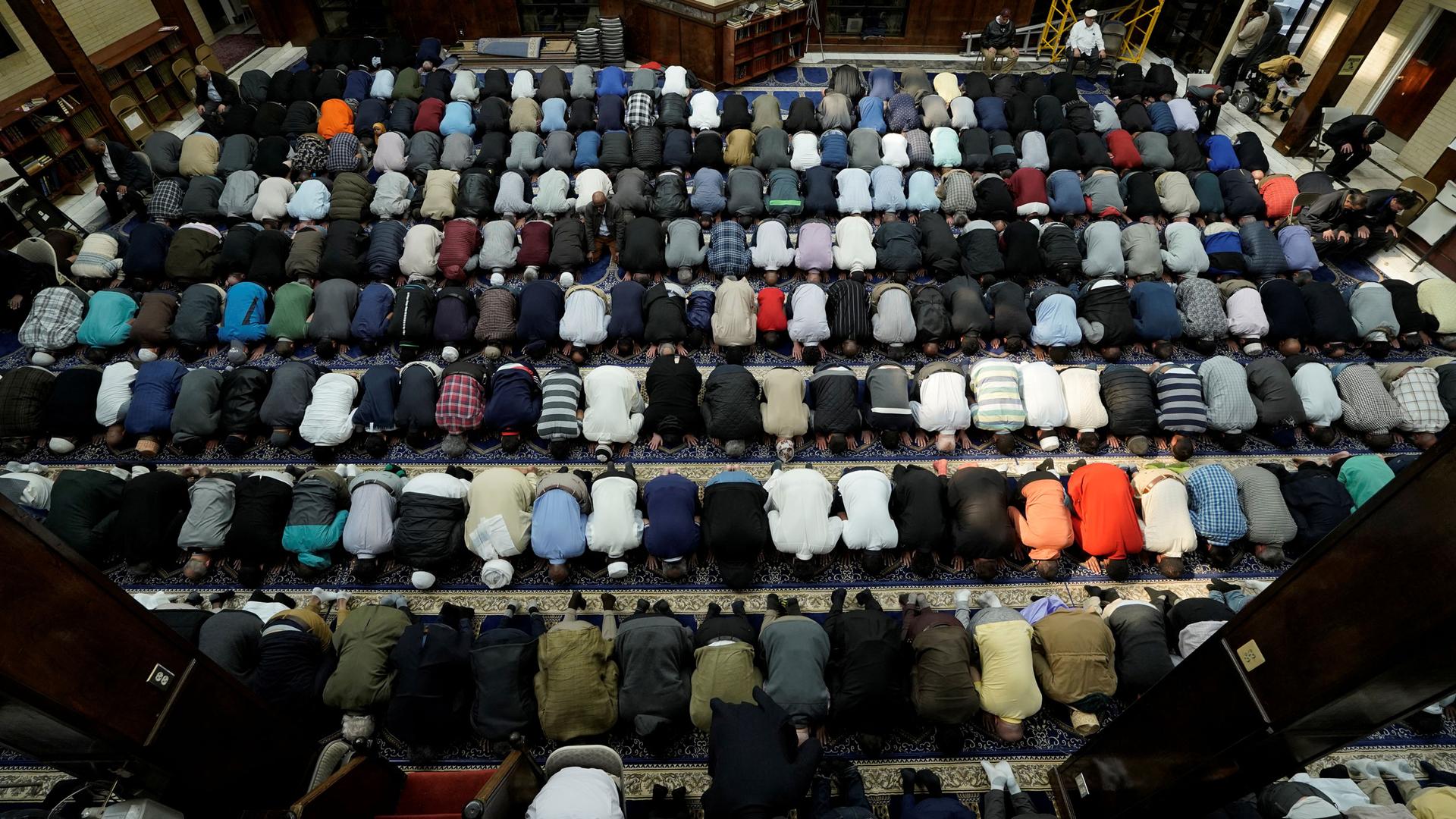 A photo taken overhead shows dozens of Muslims praying in a mosque