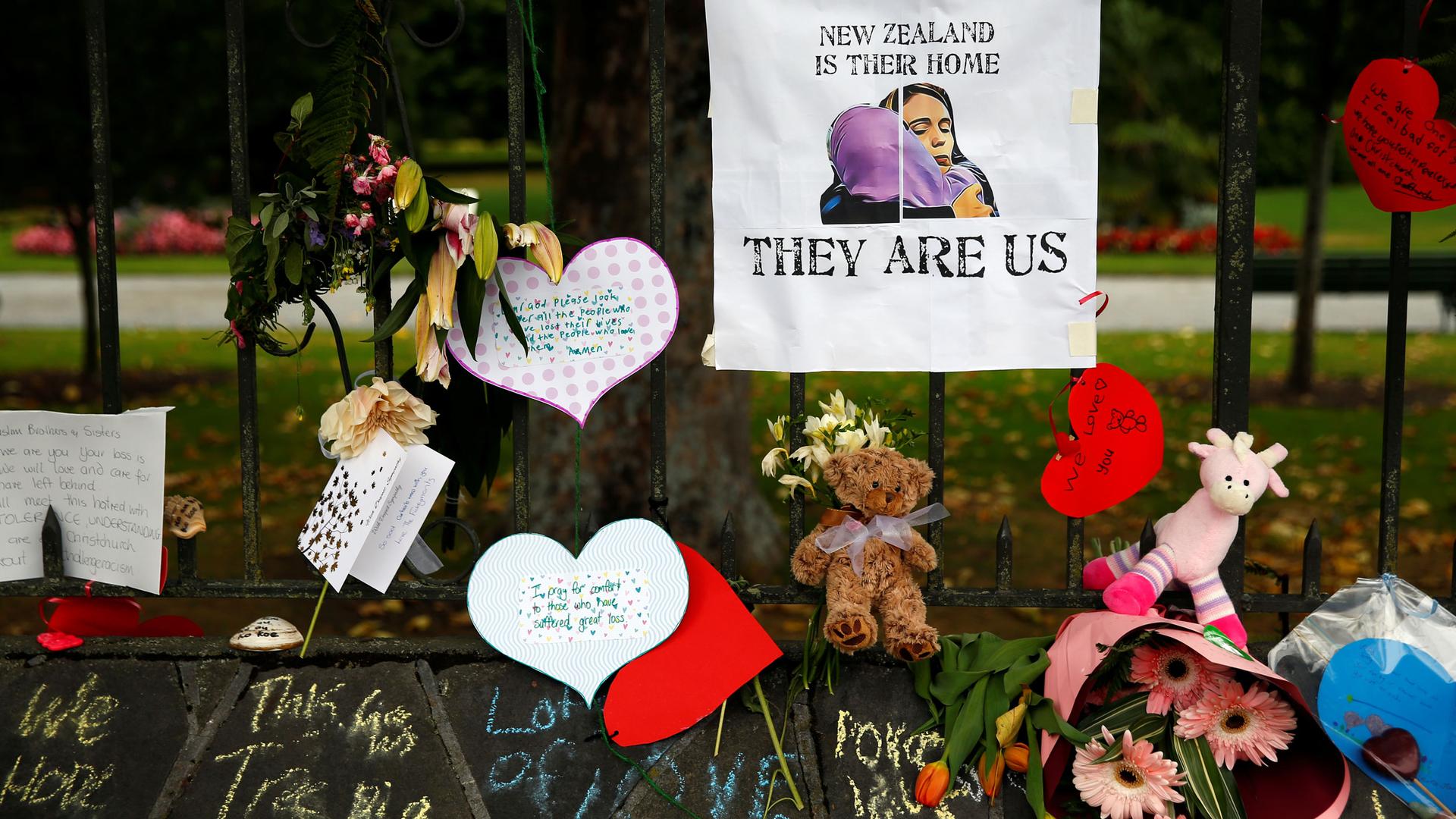 Flowers, cards and stuffed animals decorate a face as a tribute to victims of the Christchurch mosque shootings