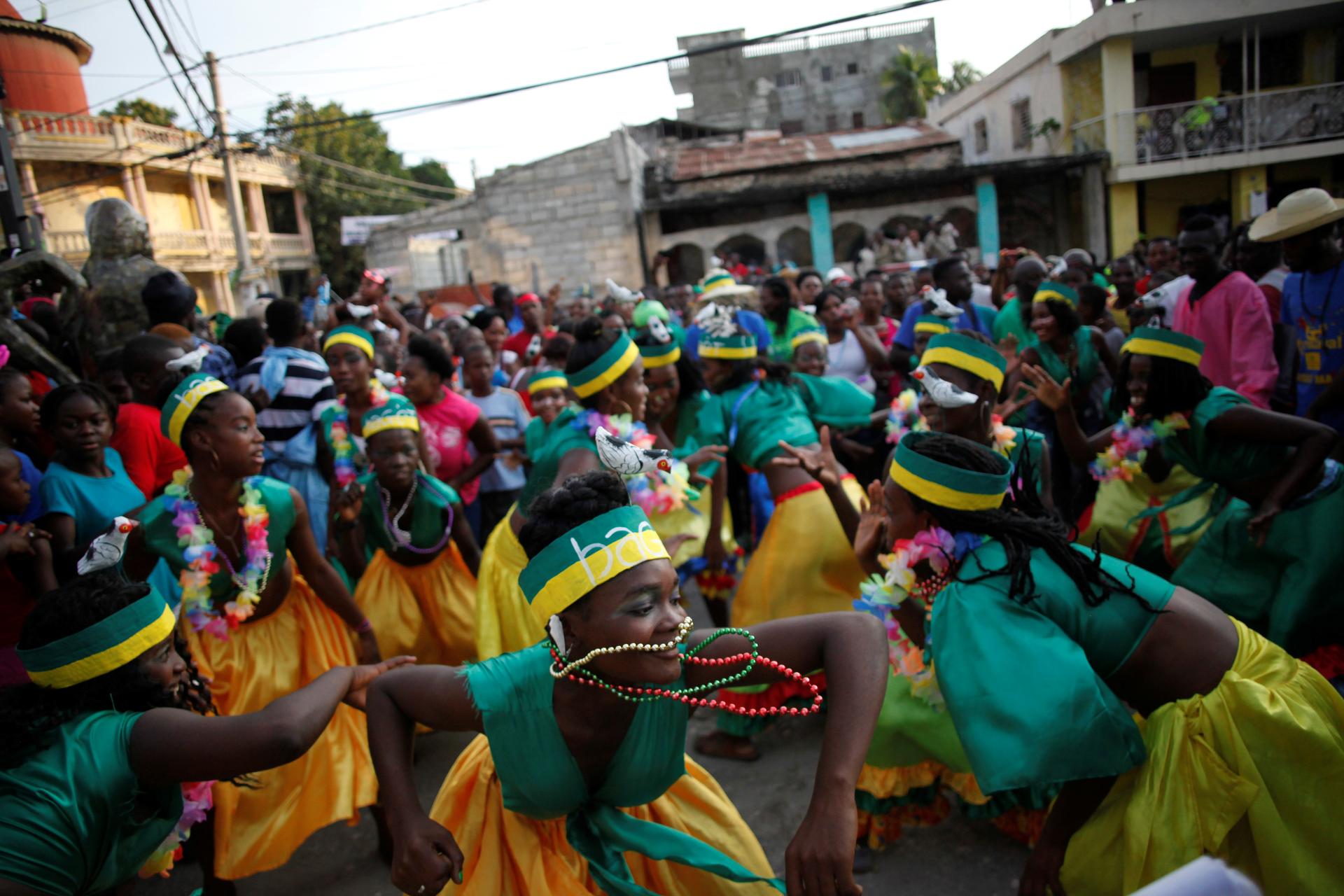 Women in green and yellow costumes dance