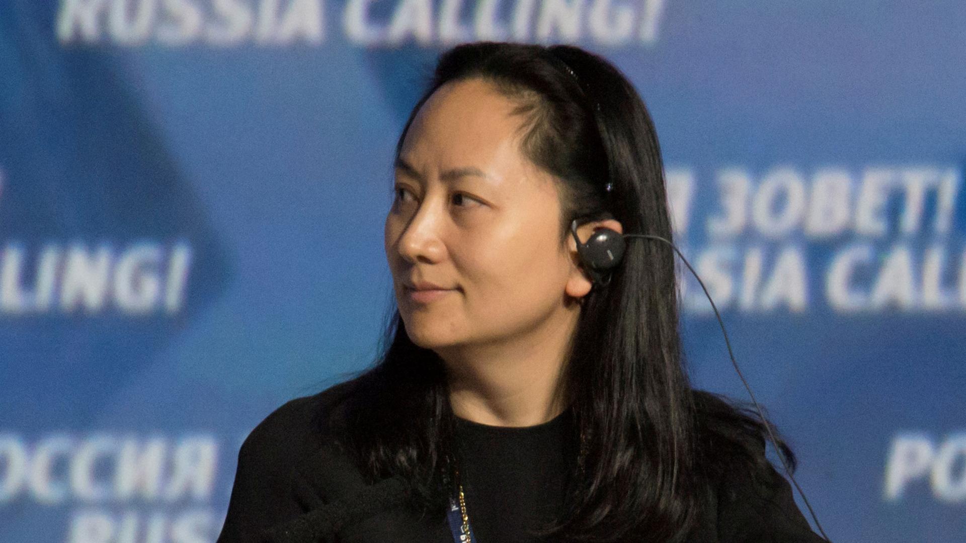 Meng Wanzhou is show in a profile photograph looking to her right and wearing an audio device in her ear.