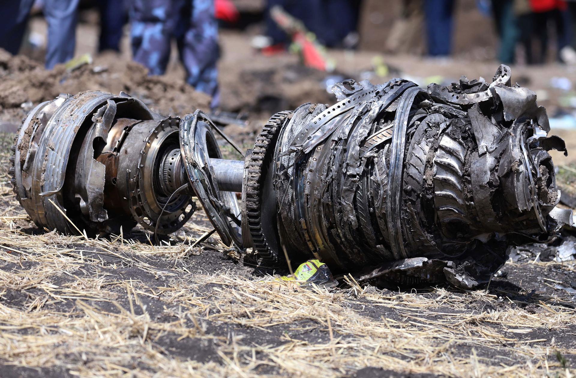 Large metal airplane engine parts are shown laying on the ground in Ethiopia.