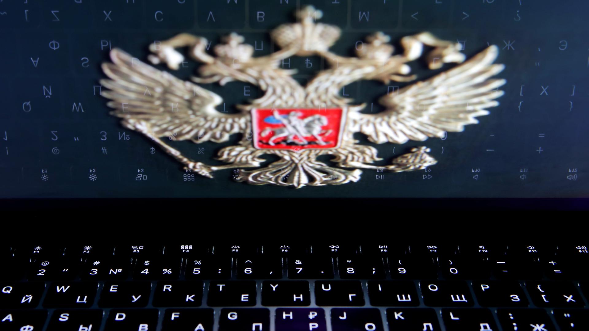 The coat of arms of Russia is reflected in a laptop screen in this picture illustration 