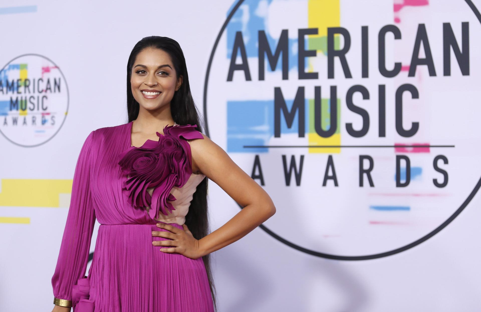 Lilly Singh poses in a magenta gown 