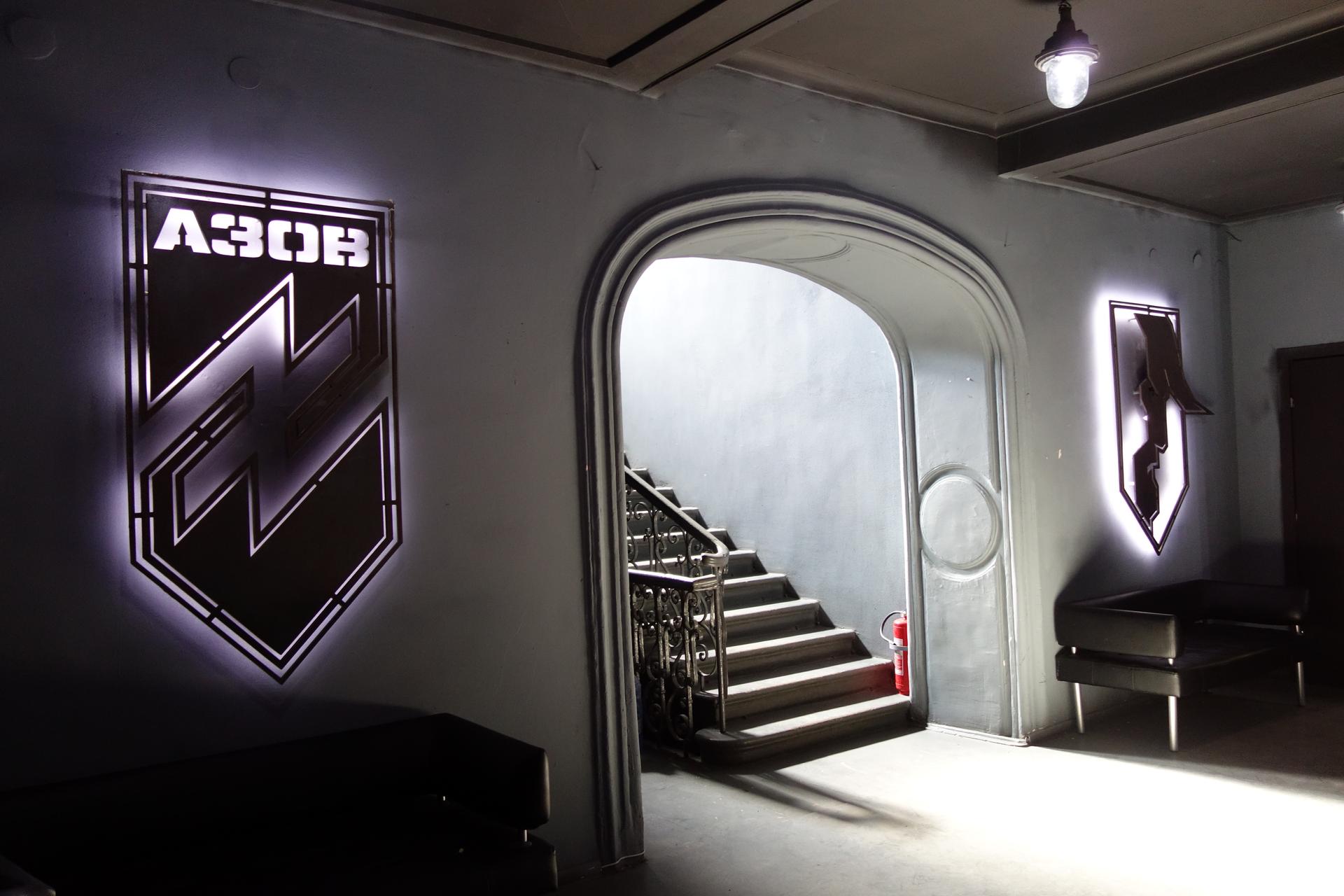 hallway with lit up black and white logo on the wall