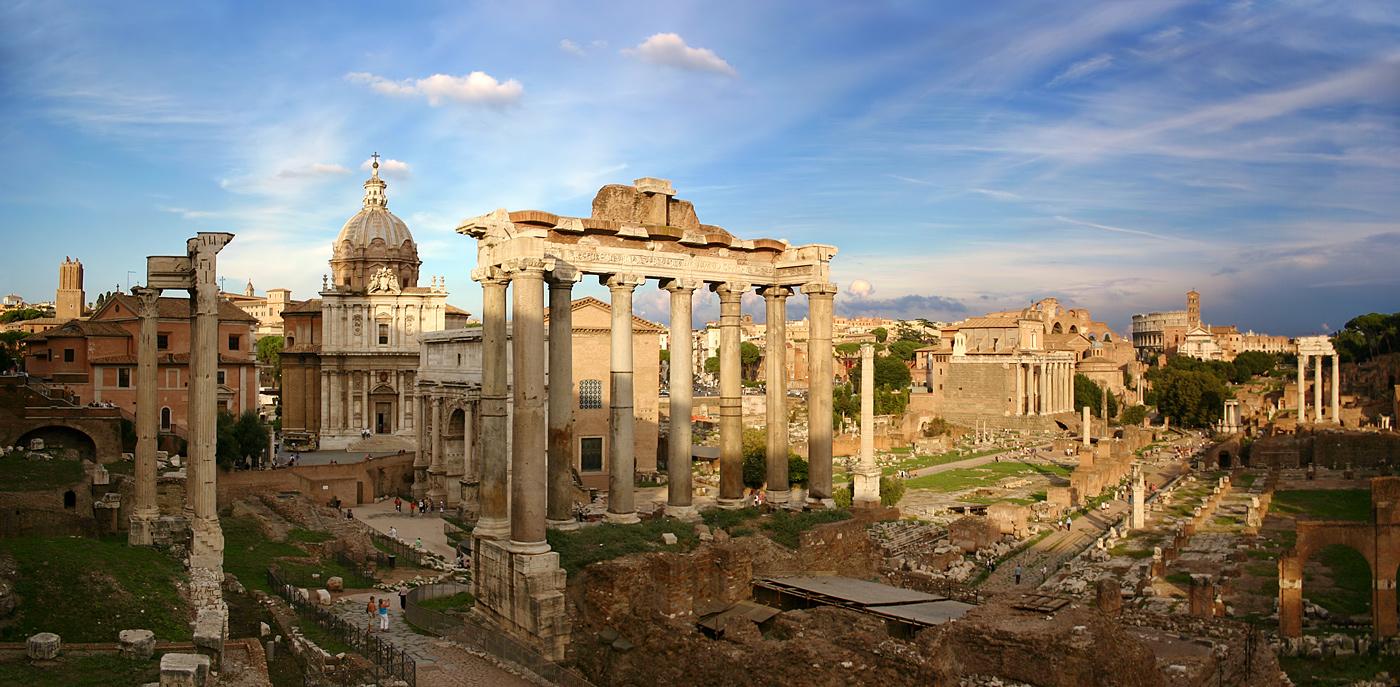 Columns, foundations, and churches spread out around the city of Rome on a sunny day.