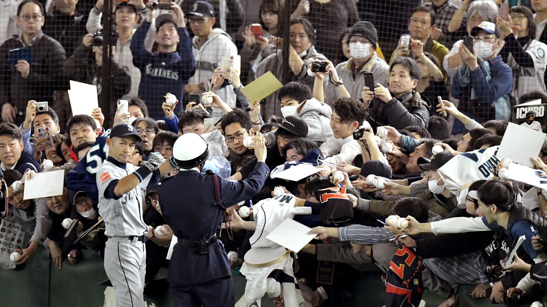 Seattle Mariners' outfielder Ichiro Suzuki gives autographs to fans before an exhbition game in Tokyo against the Yomiuri Giants, March 17, 2019.