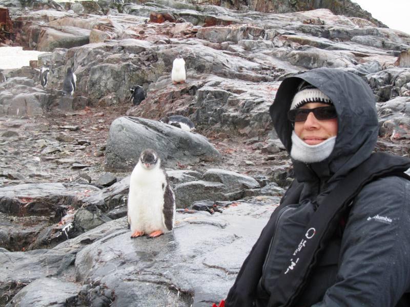 A woman takes a selfie with a penguin