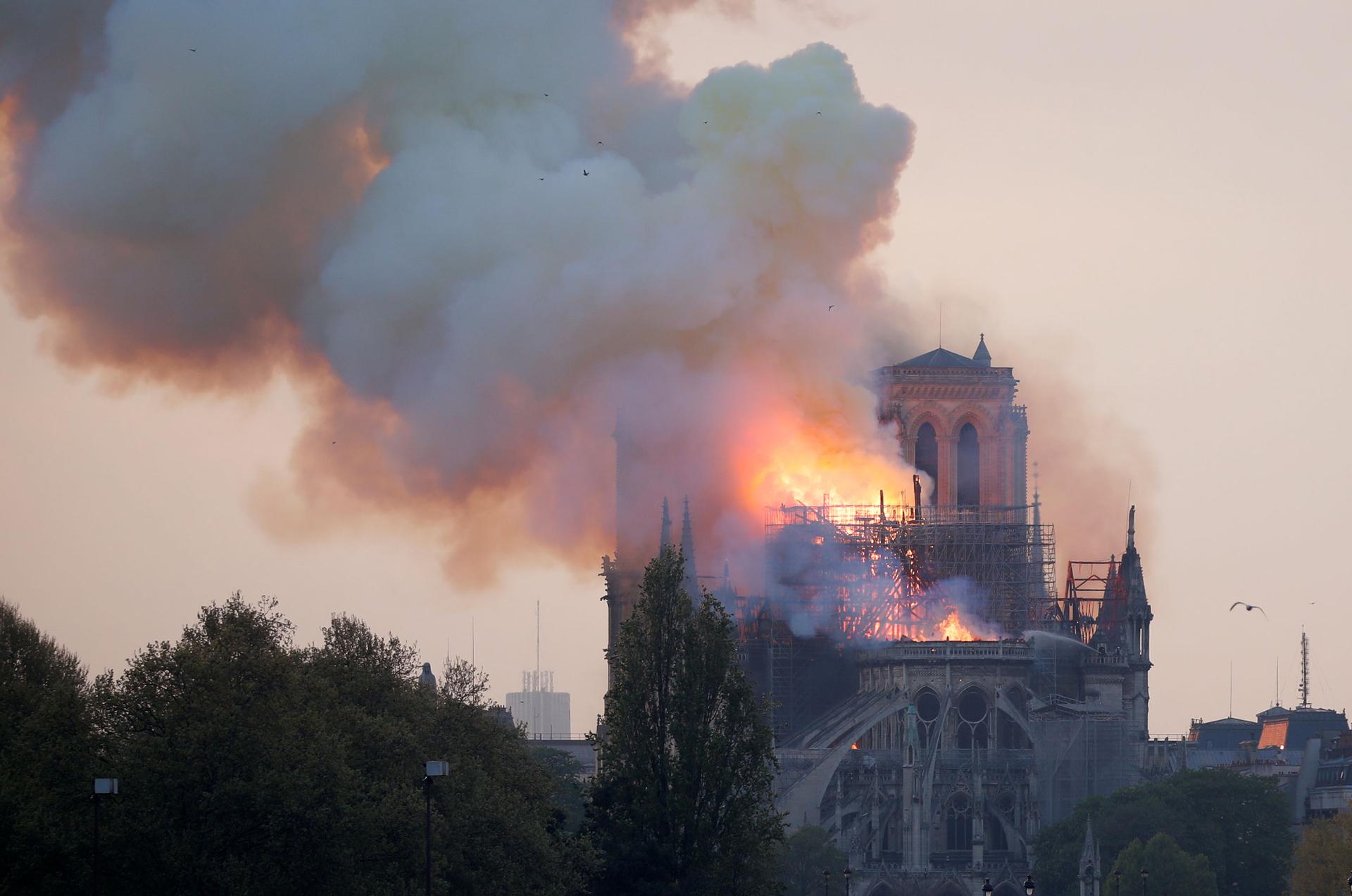 A photo shows the top of the Notre Dame cathedral on fire.