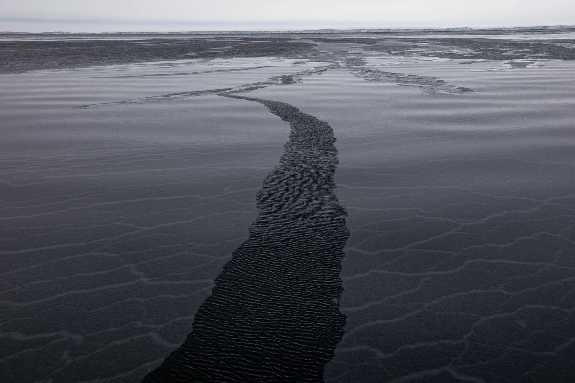 A narrow break in new ice is shown in the middle of the photo on a gray day in the Amundsen Sea.