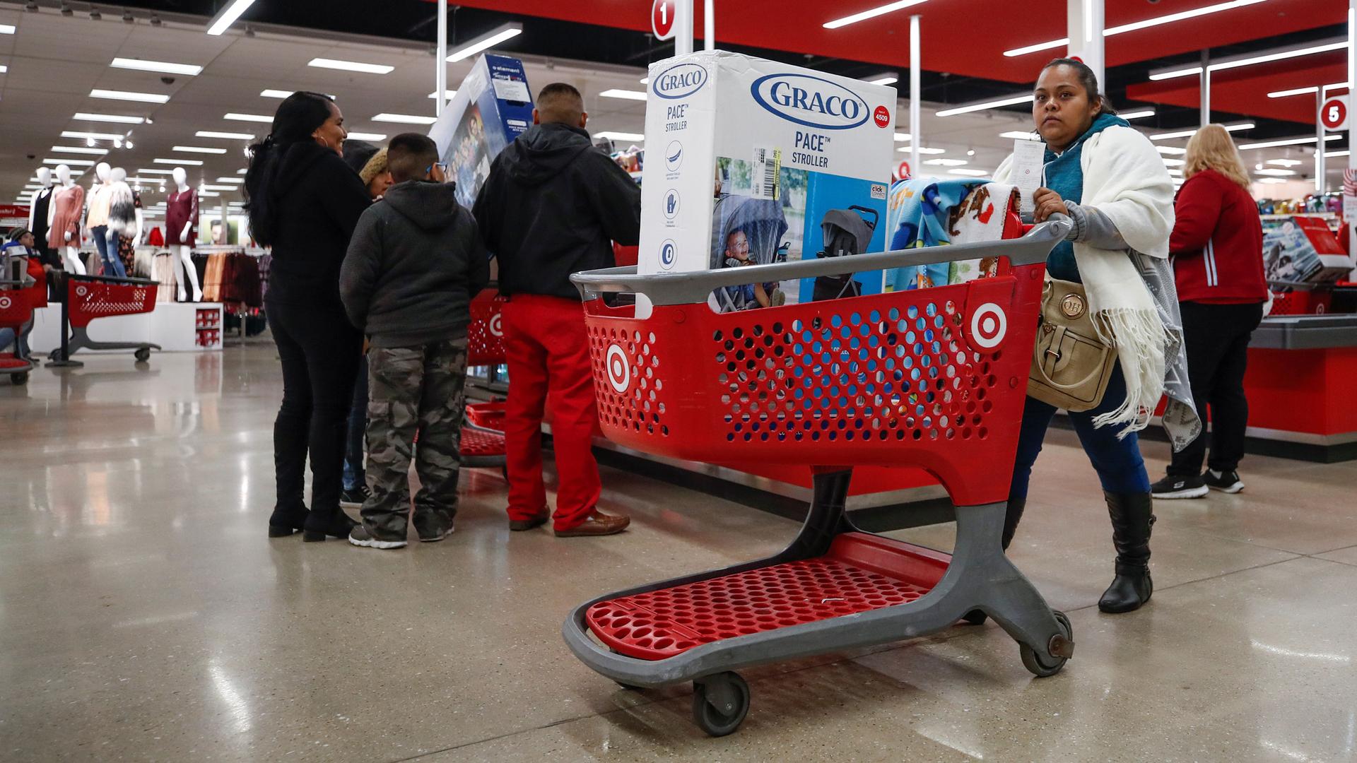 A customer pushes her shopping cart, filled with Chinese-made products, after making a purchase at a Target in Chicago, Illinois.