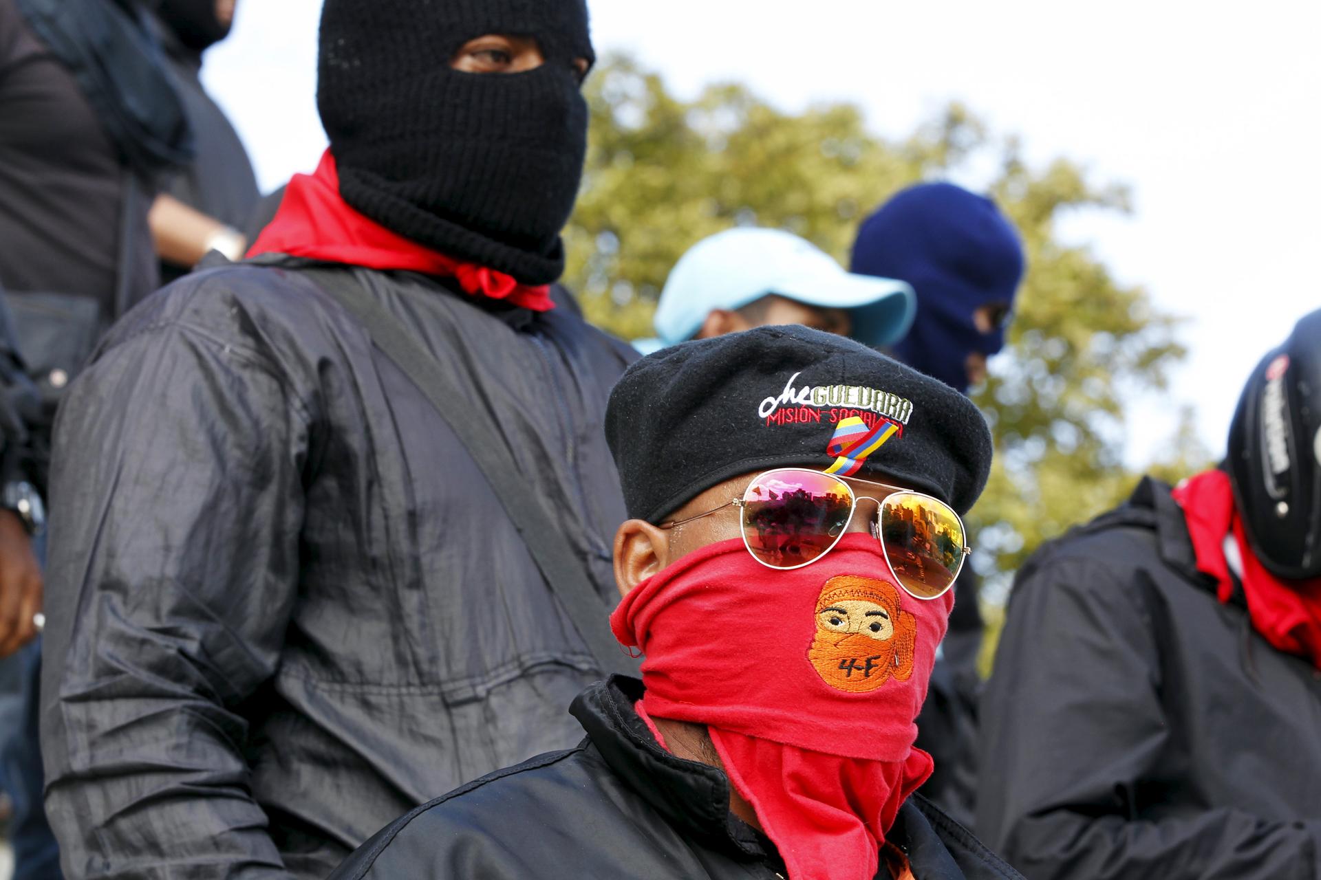 A man wears a red mask over his mouth and sunglasses