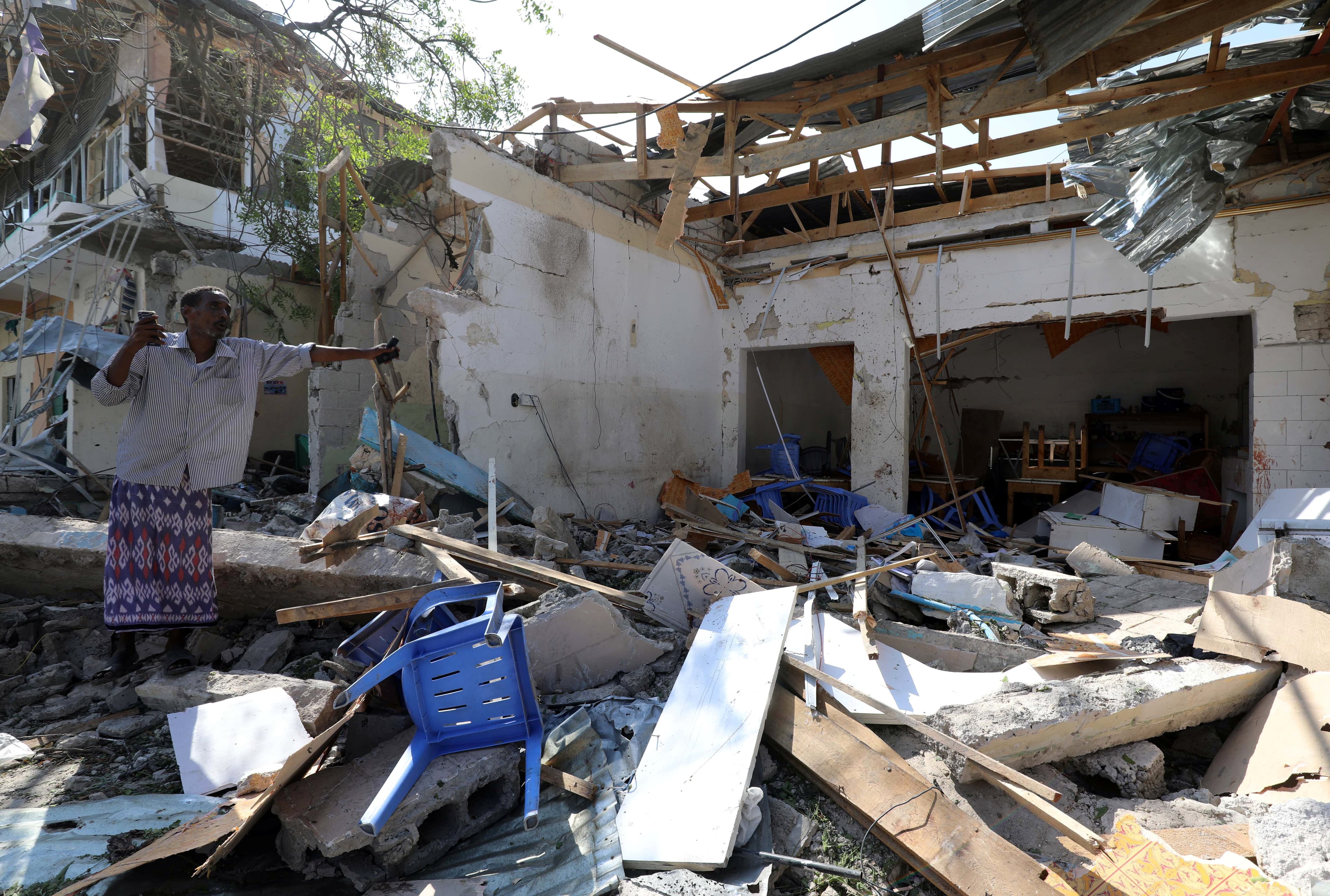 Somali man stands in ruins of rubble.