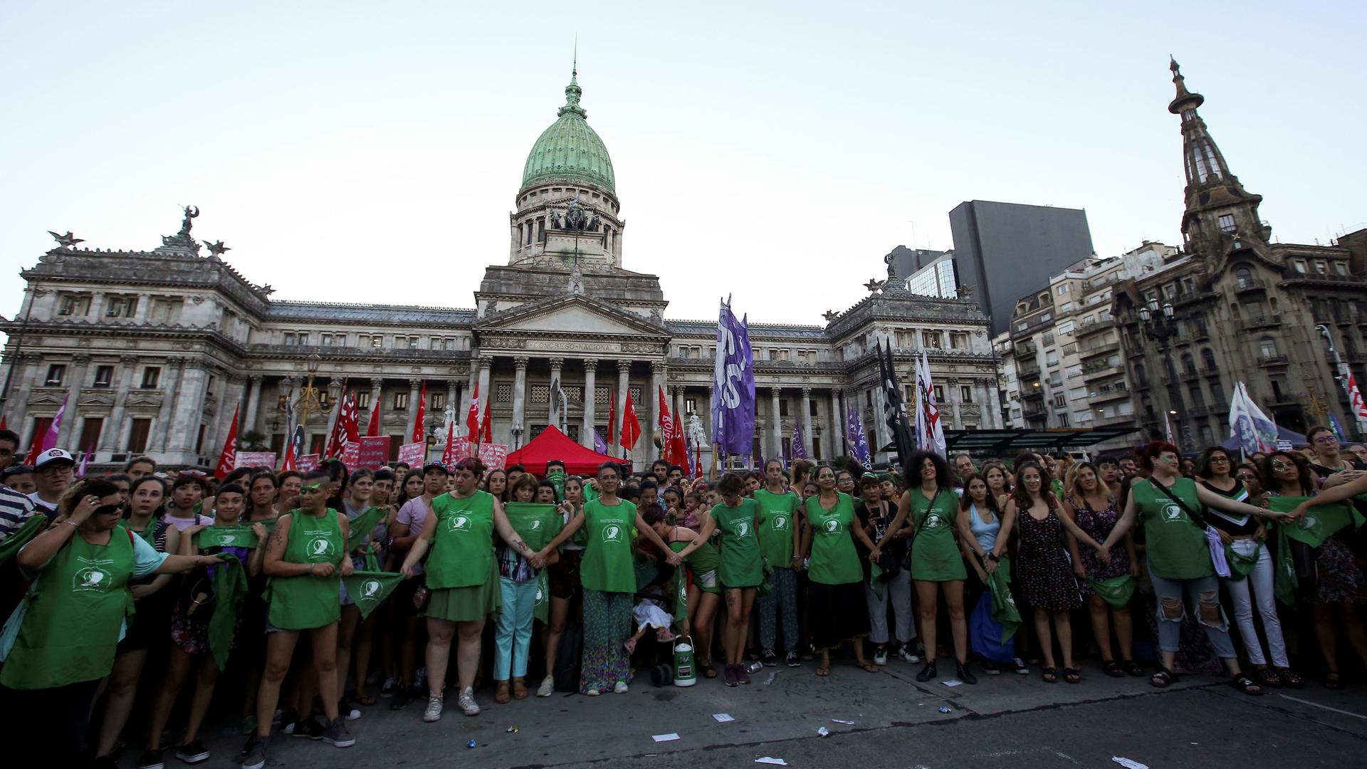 Activists hold hands outside the National Congress in Argentina. 