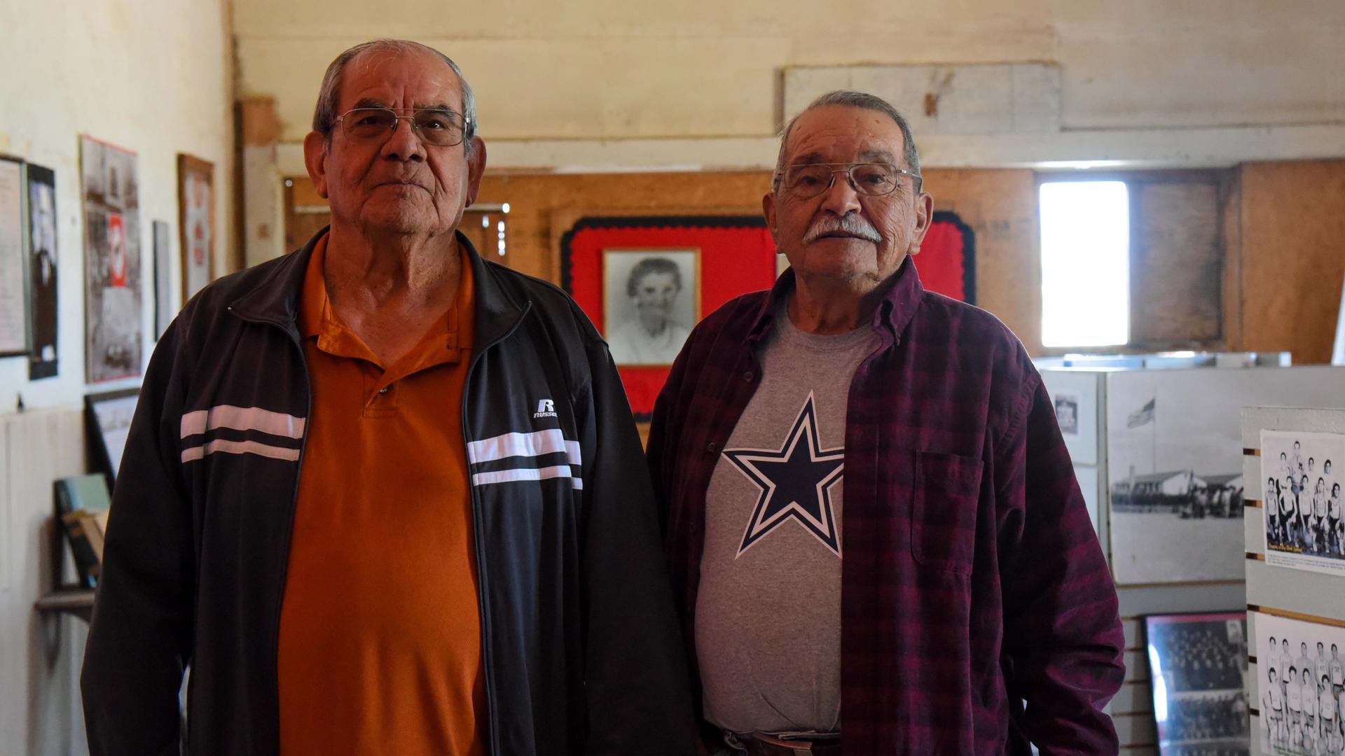 Two older Mexican American men pose for a photo.