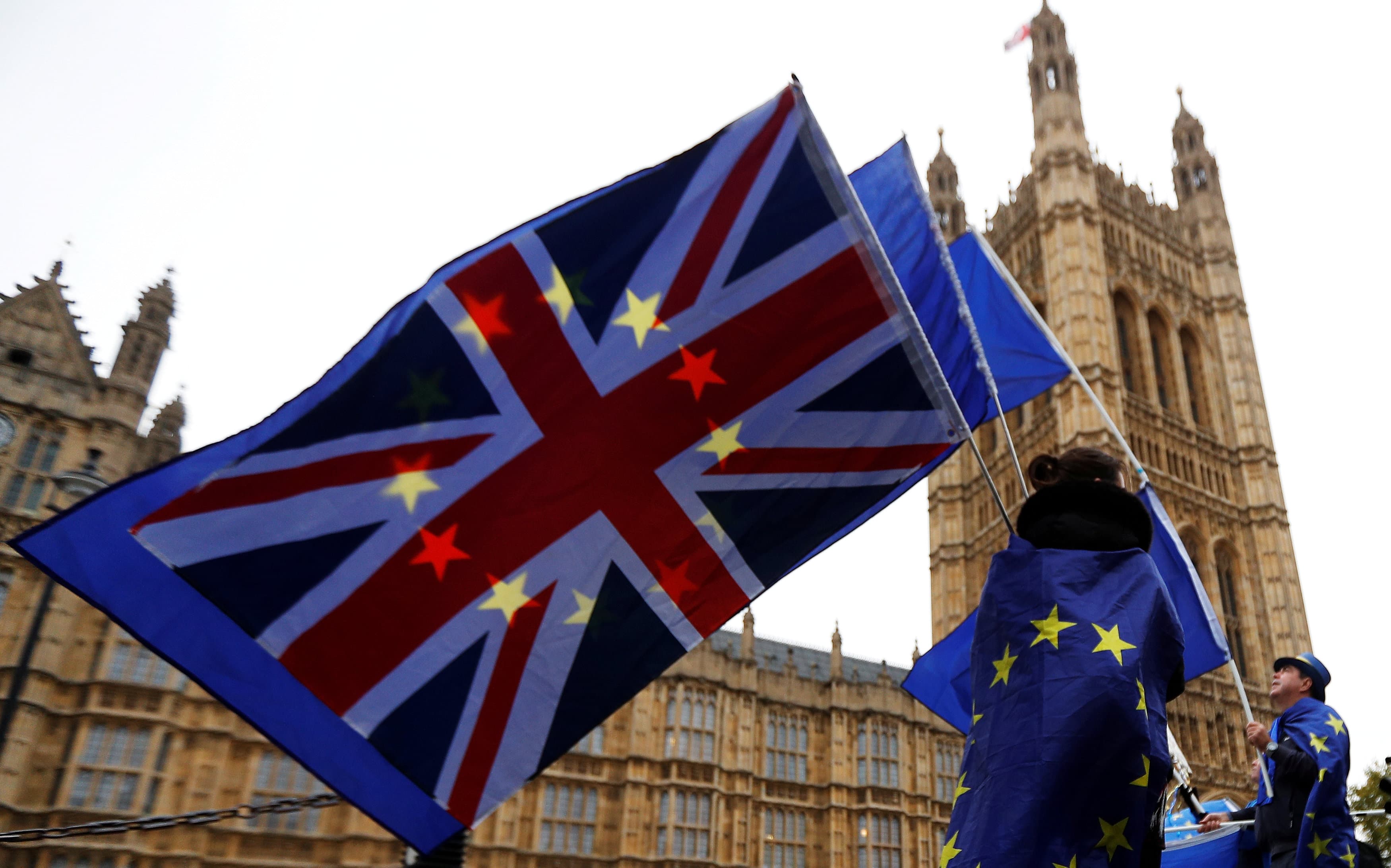 Anti-Brexit protesters wave EU and Union flags outside the Houses of Parliament