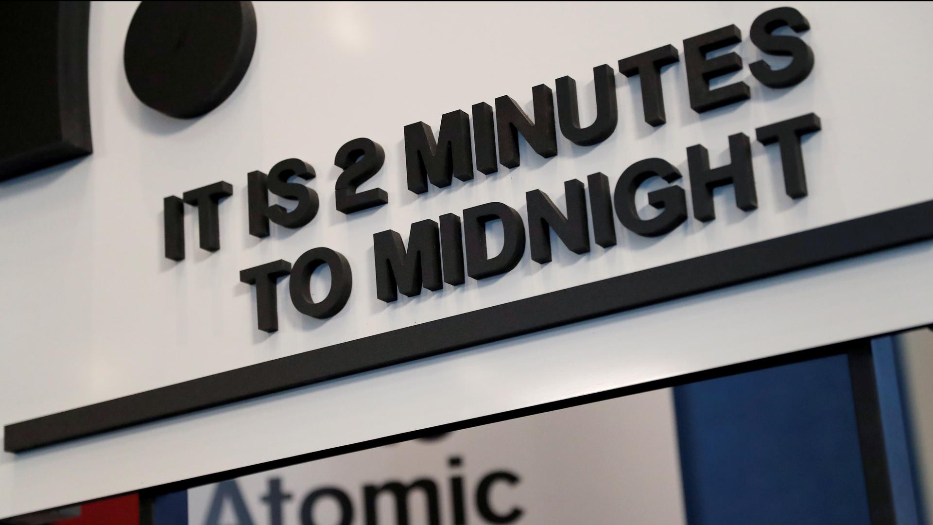 A sign reads: "It's 2 minutes to midnight"