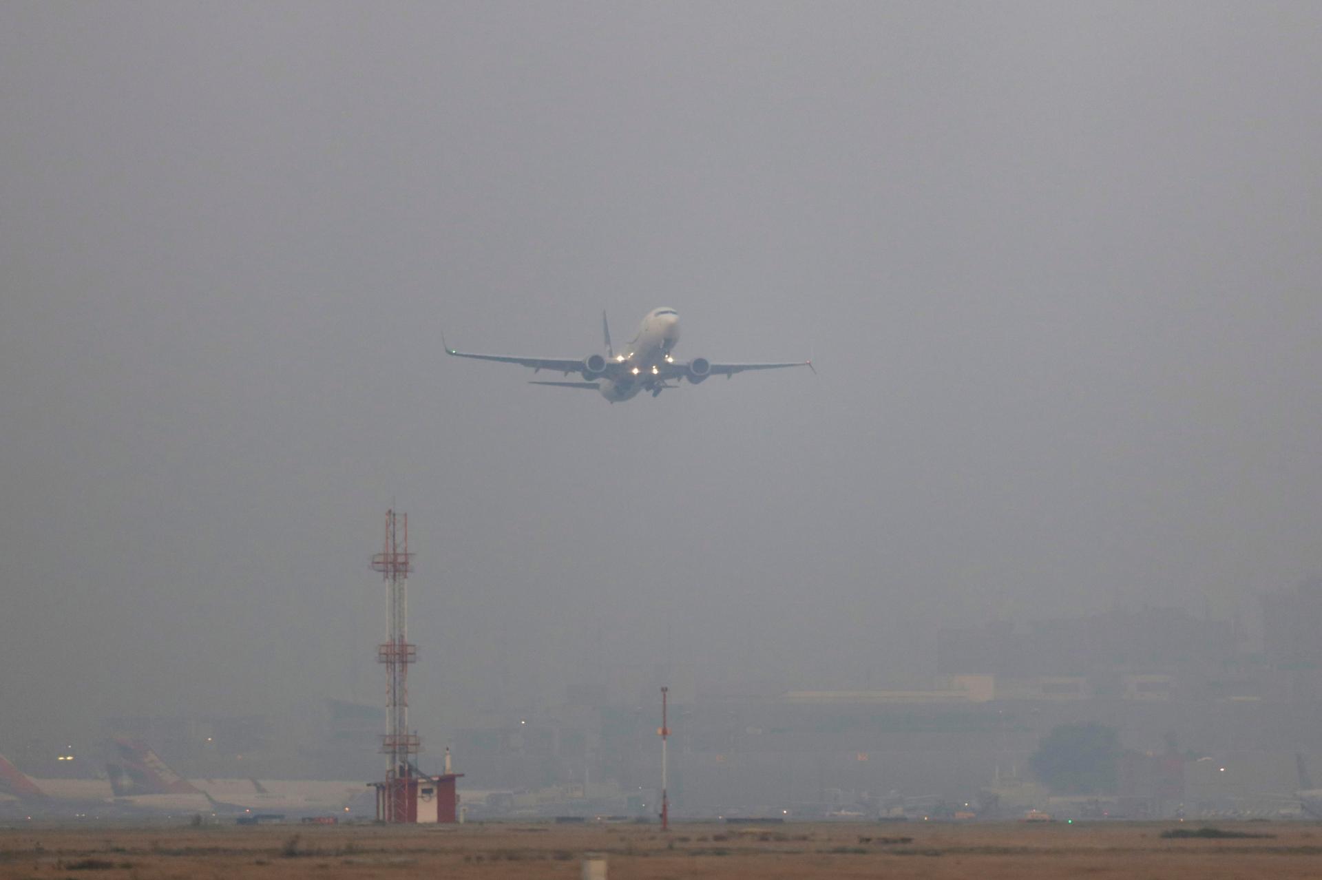 A plane takes off in smog