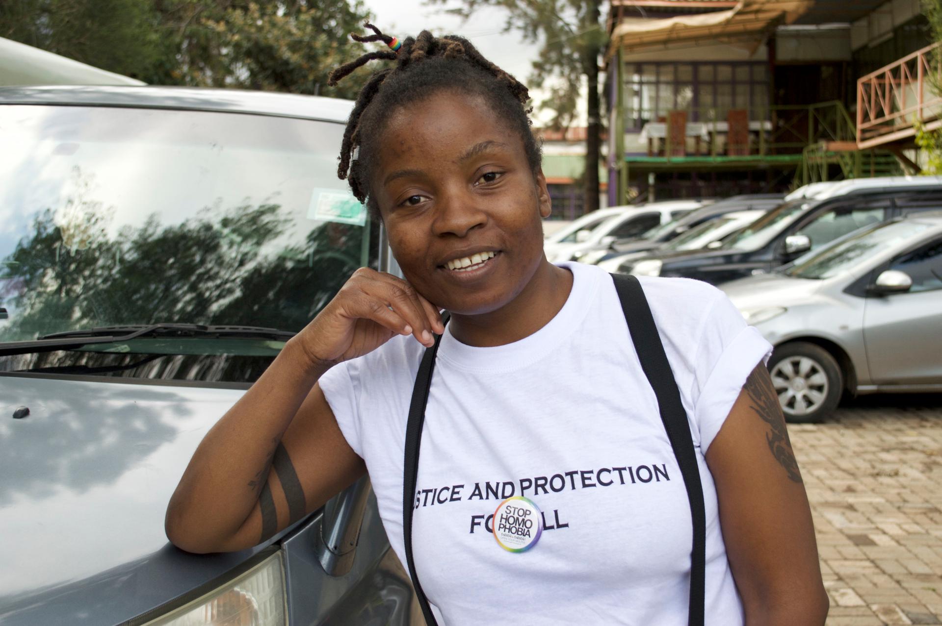 A woman poses for picture wearing white t-shirt and hand on her face.