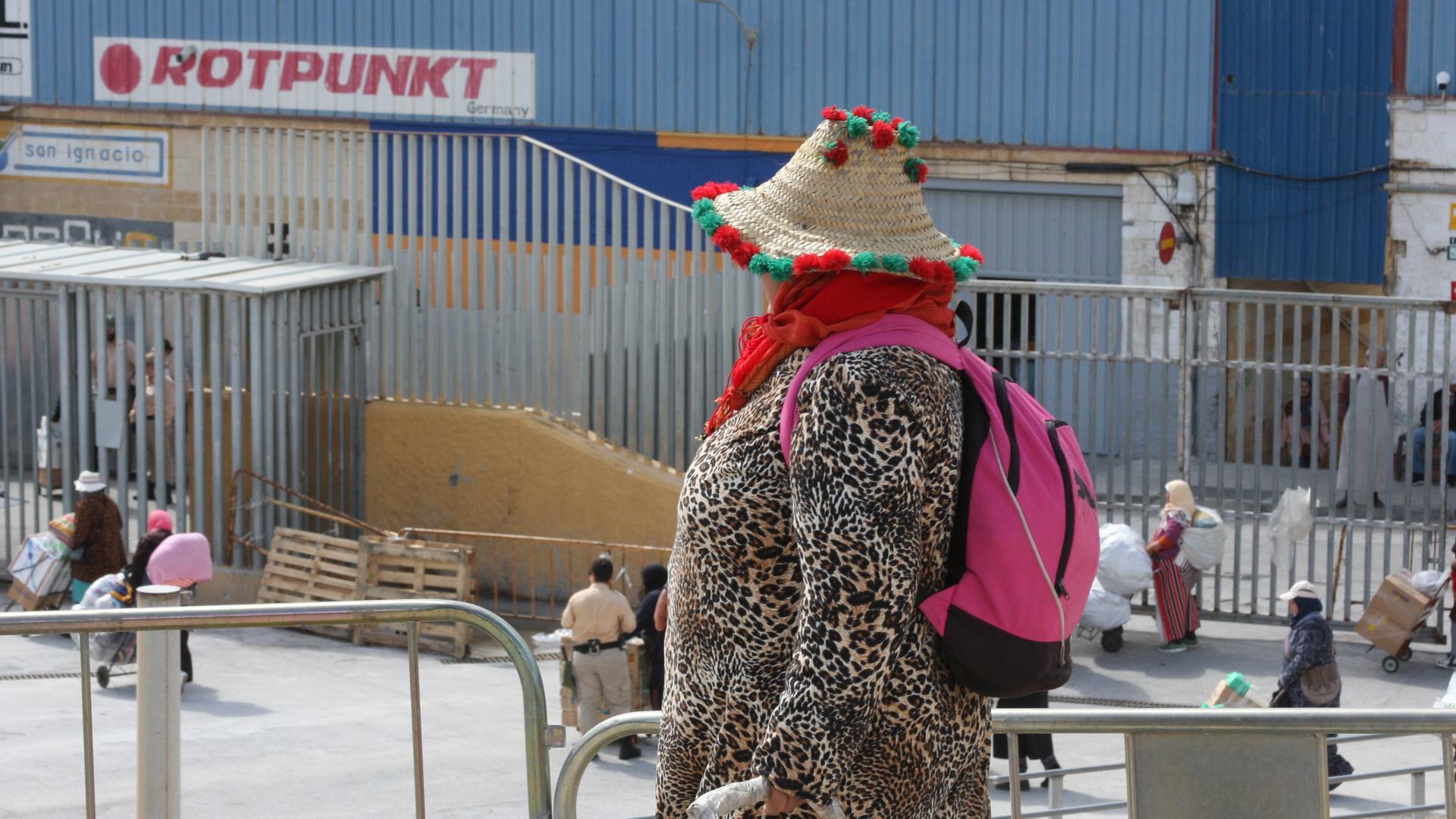 A woman porter in Ceuta wears colorful straw hat and leopard print jacket