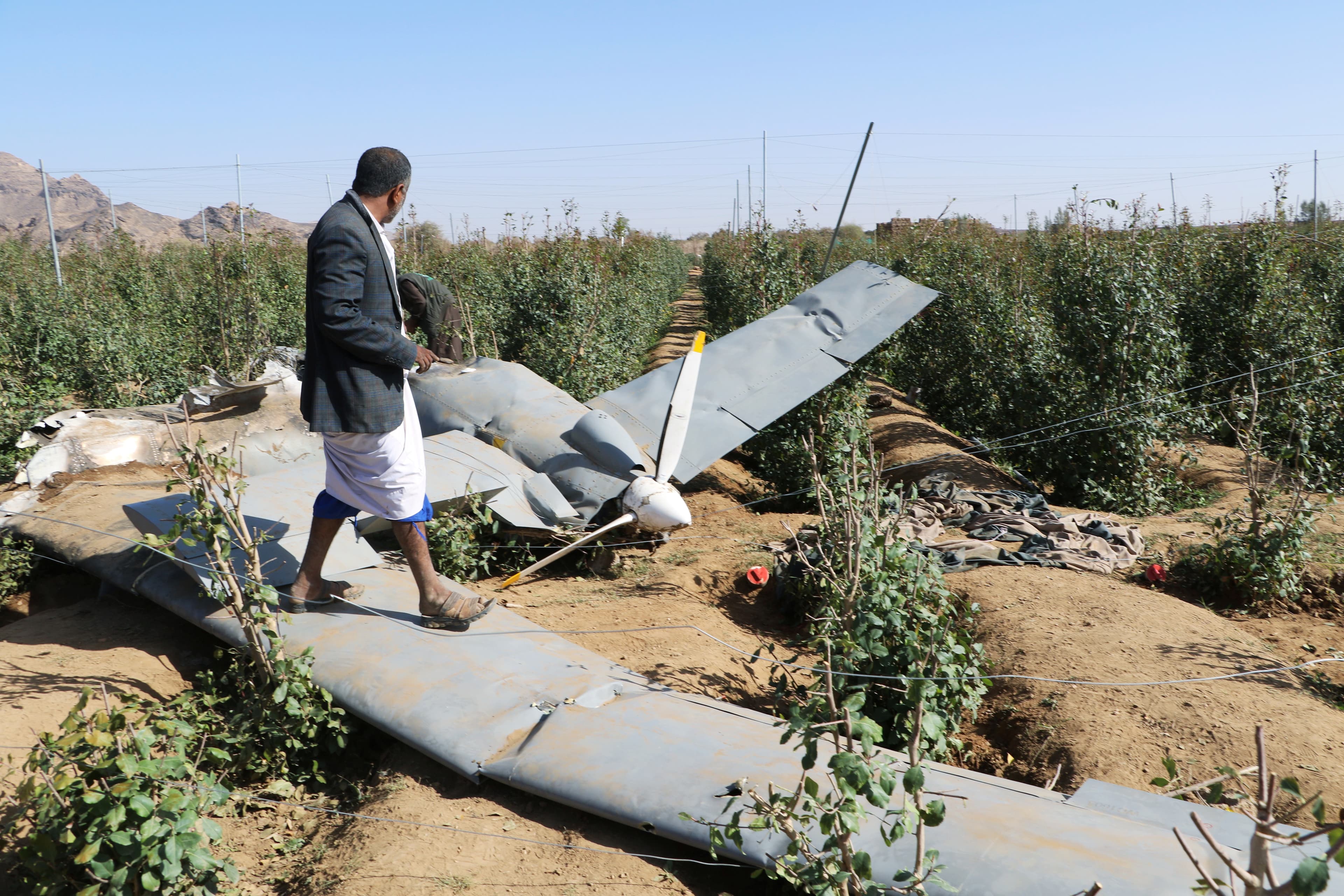 people inspect part of shot down drone