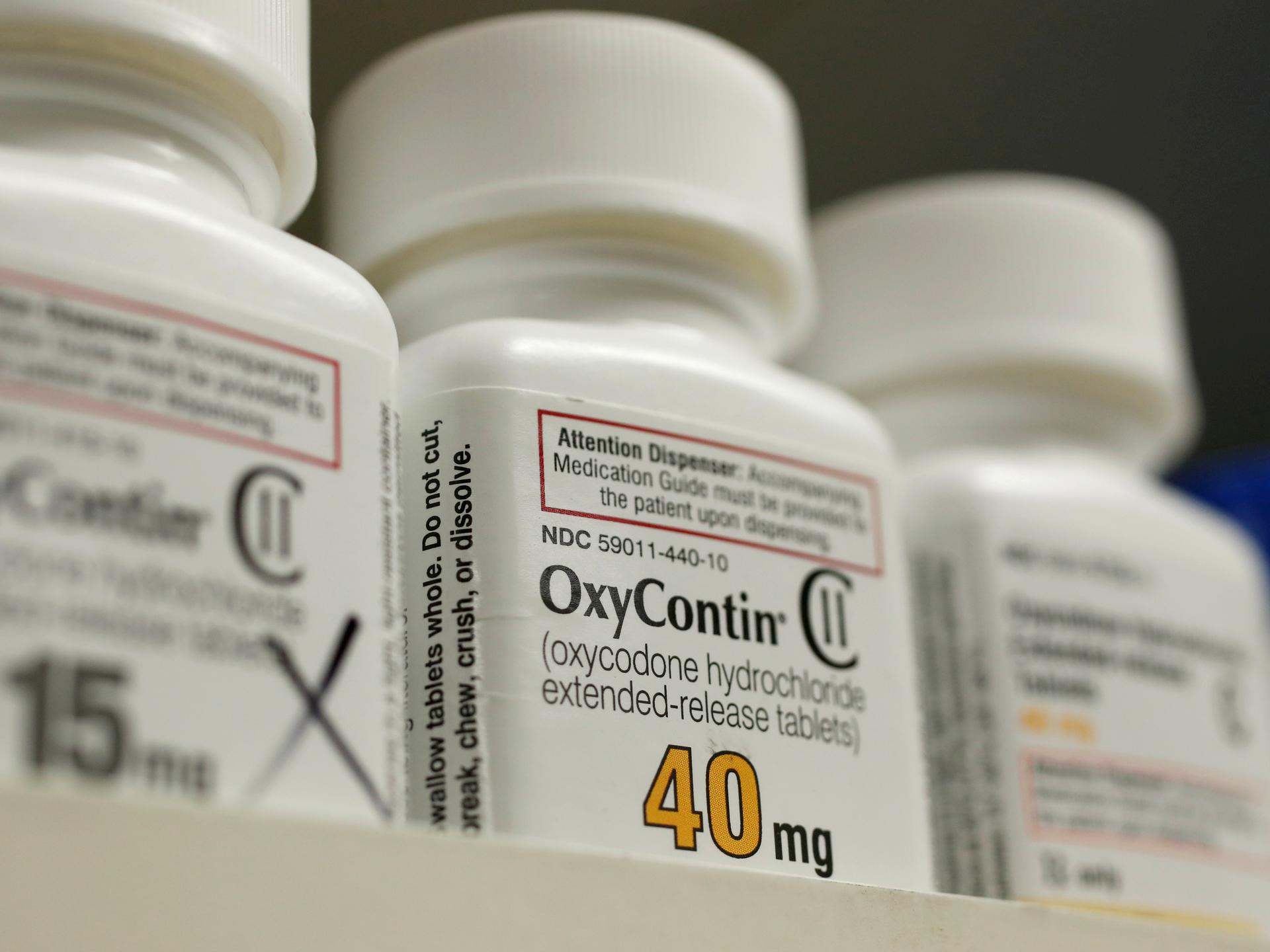 a white bottle of Oxycontin sits on a shelf. 