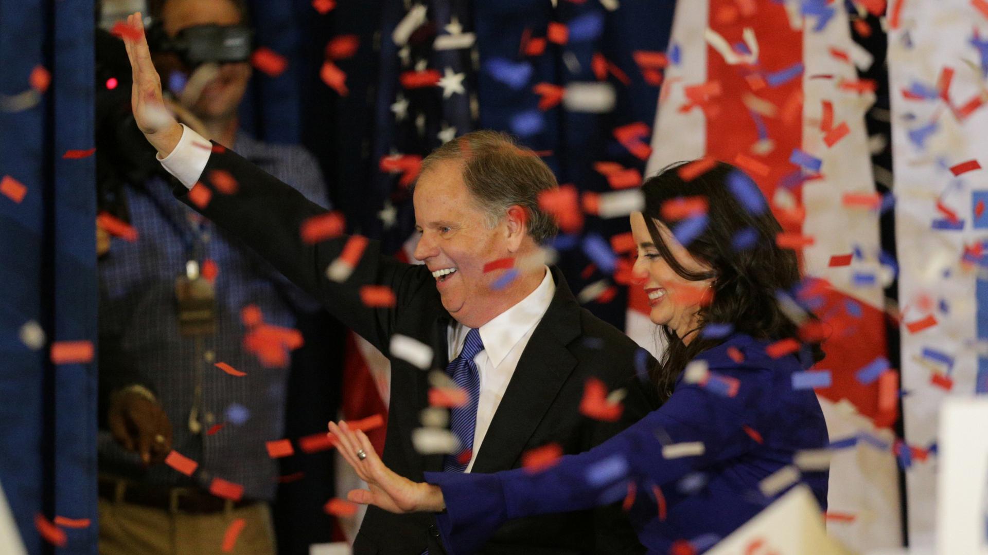 Democratic Alabama US Senate candidate Doug Jones and wife Louise smile and celebrate as red, white and blue confetti falls.