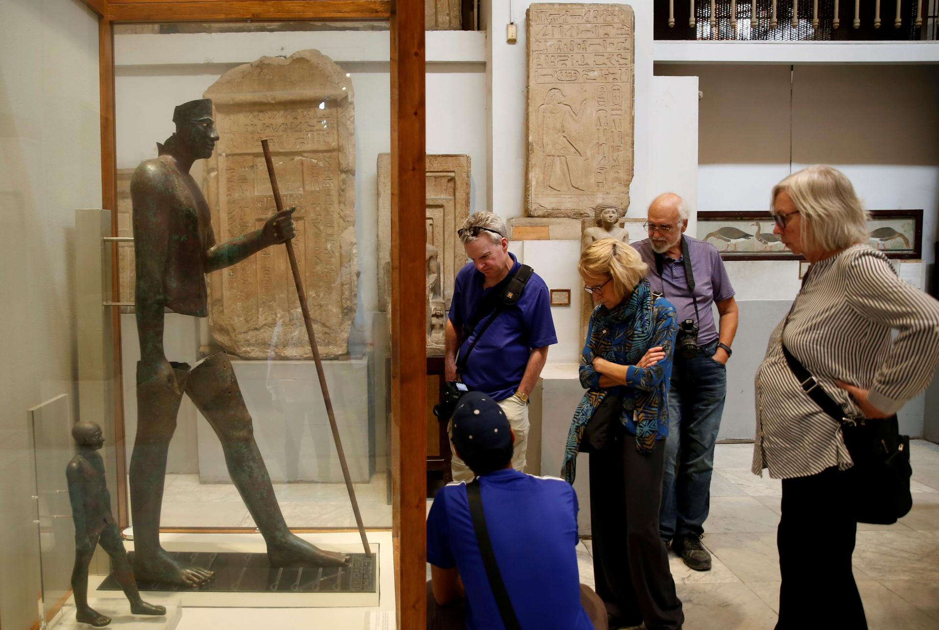 Visitors walk around pharaonic artefacts inside the Egyptian Museum