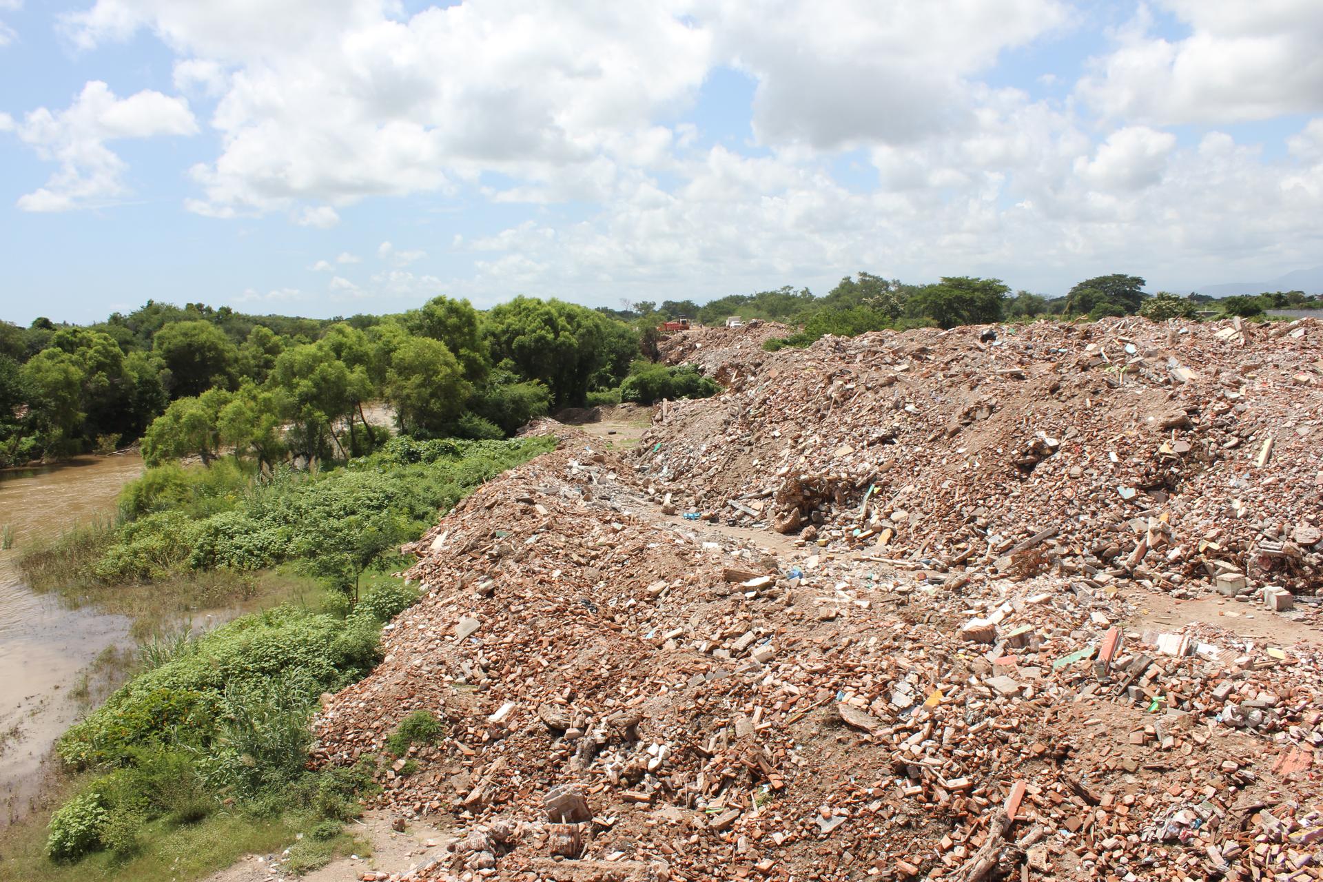 dumping thousands of tons of unsorted rubble along the banks of the Los Perros River in Ixtaltepec