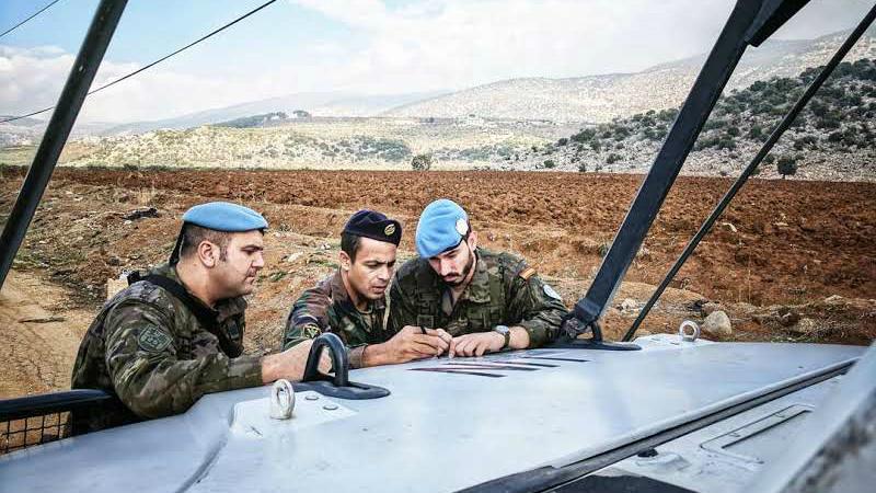 A Lebanese army soldier and two UNIFIL peacekeepers discuss the route of their joint patrol near the Lebanon-Israel border, Nov. 29, 2017.