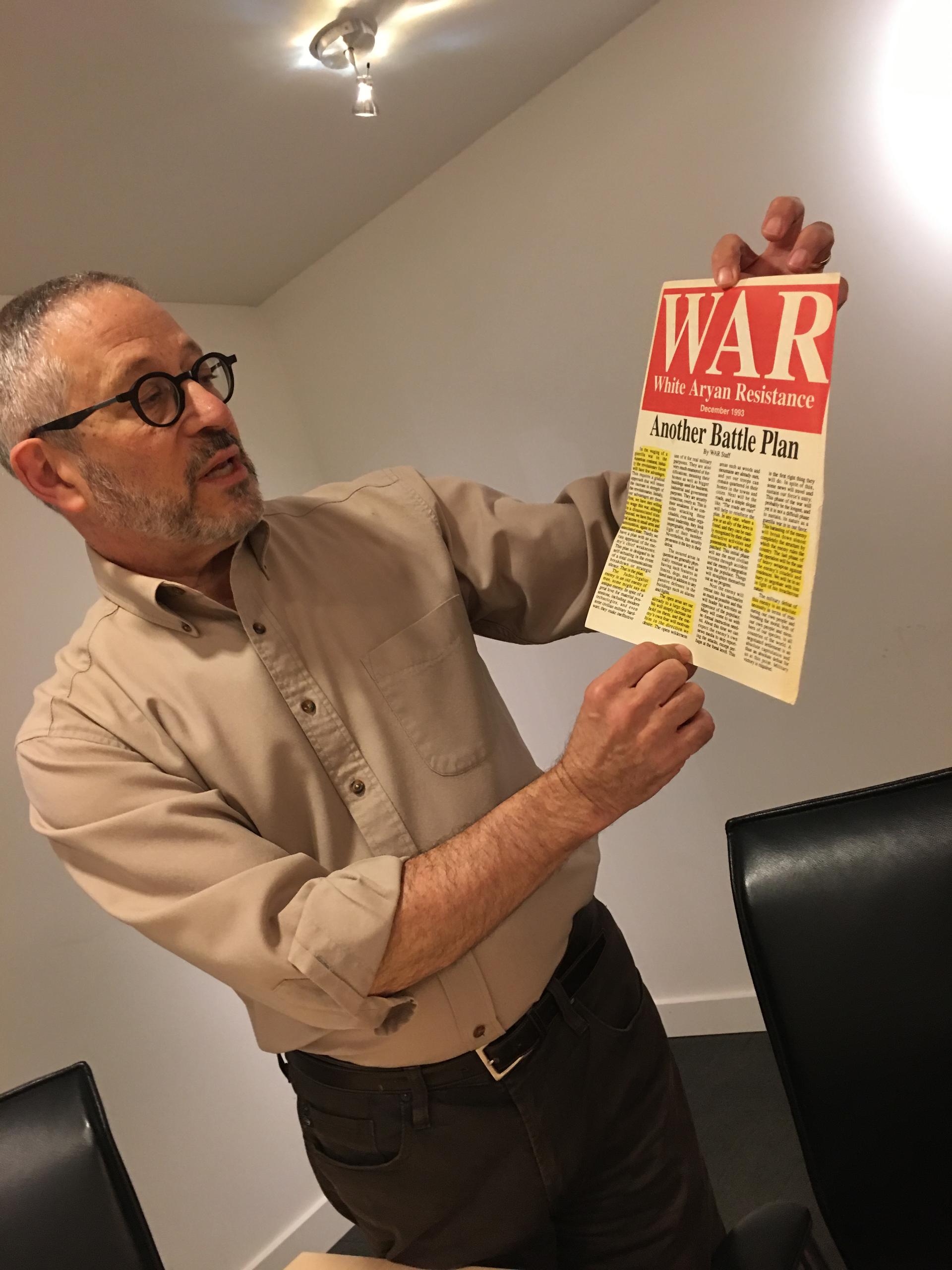 Steven Wasserstrom, a professor of Judaic studies and the humanities at Reed College, holds a piece of documentation collected by the Coalition for Human Dignity in Portland.
