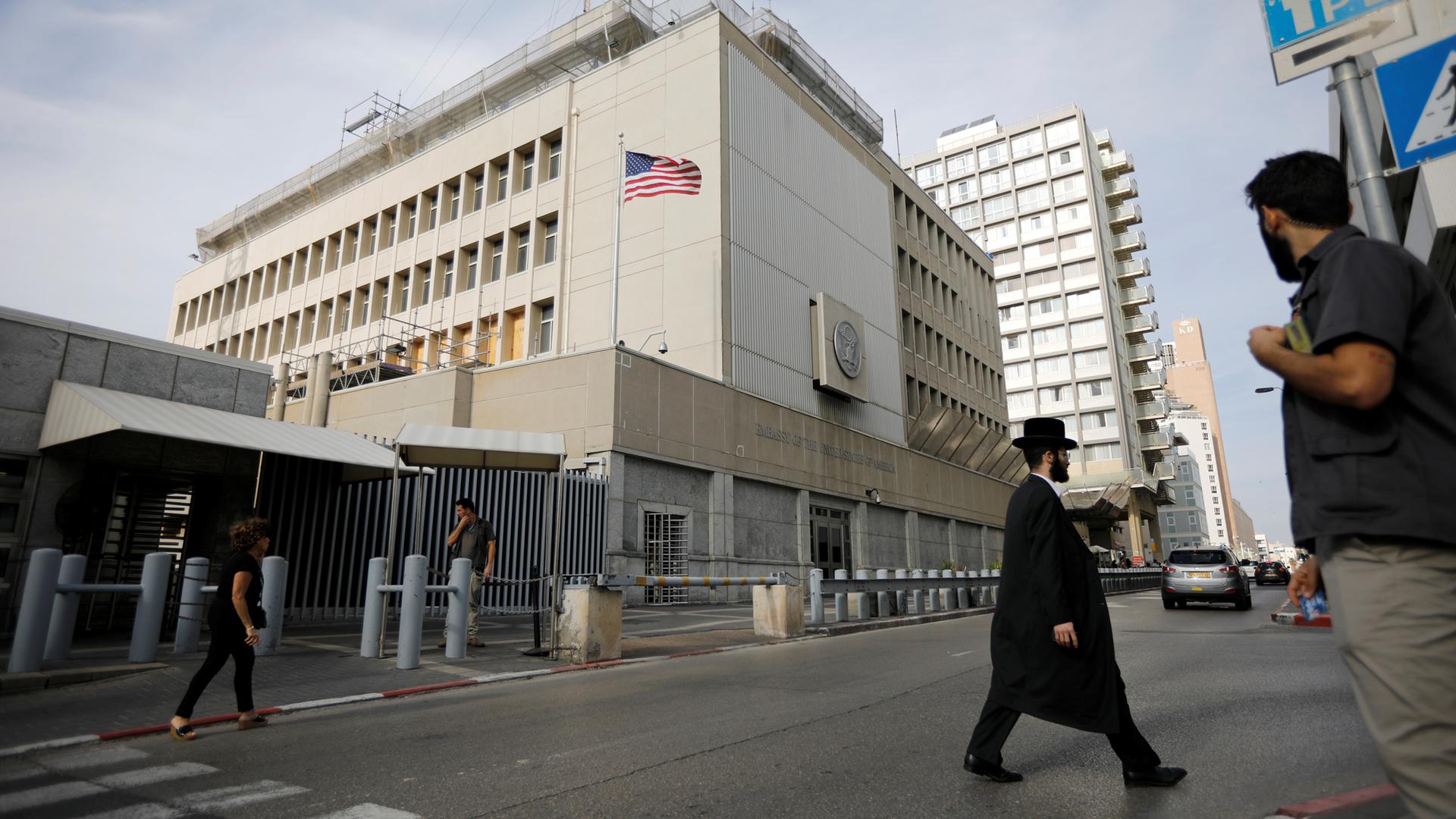 People walk past the US Embassy in Tel Aviv, Israel, Dec. 5, 2017.