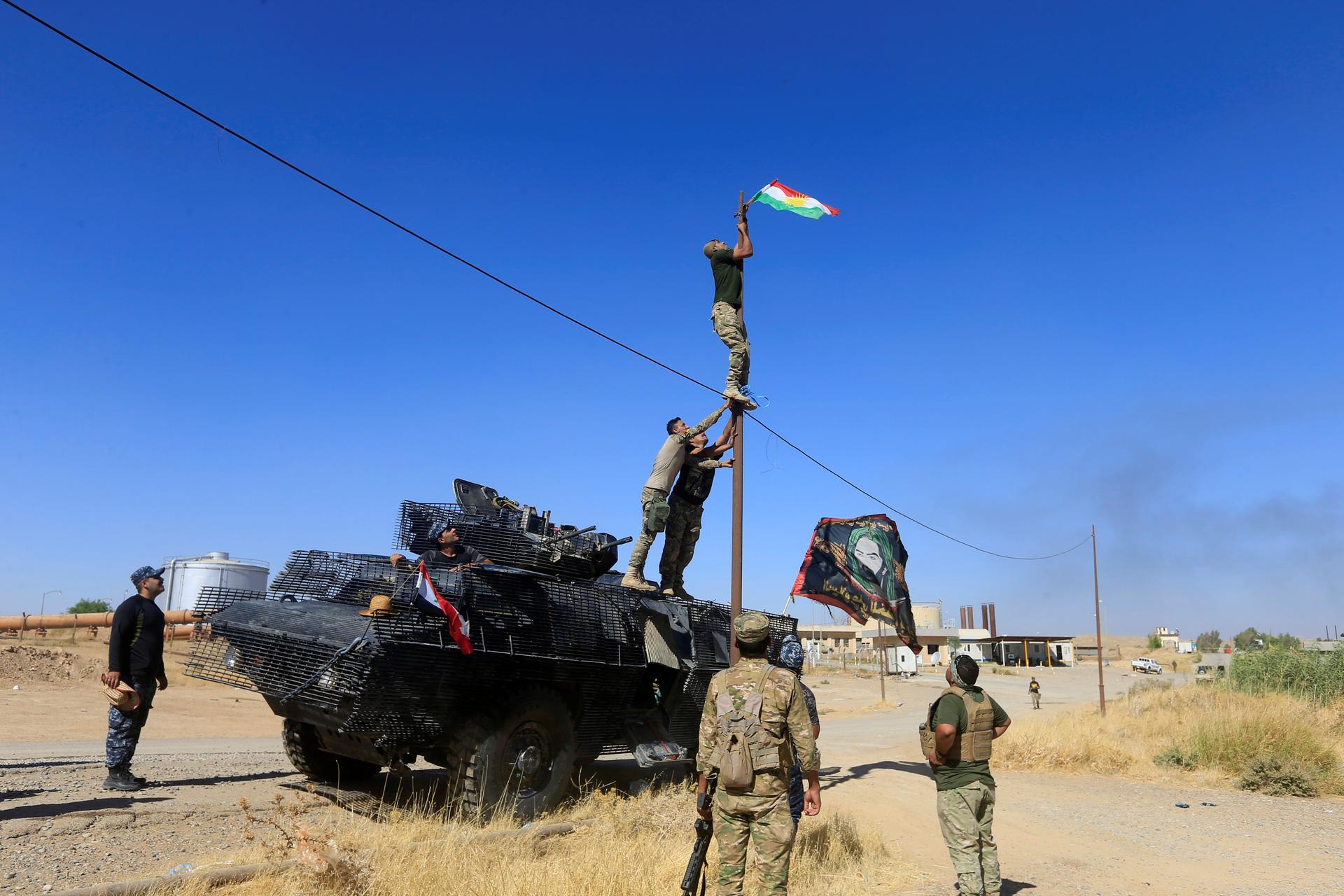 A member of Iraqi security forces takes down a Kurdish flag in Dibis on the outskirts of Kirkuk, Iraq, Oct. 17, 2017.