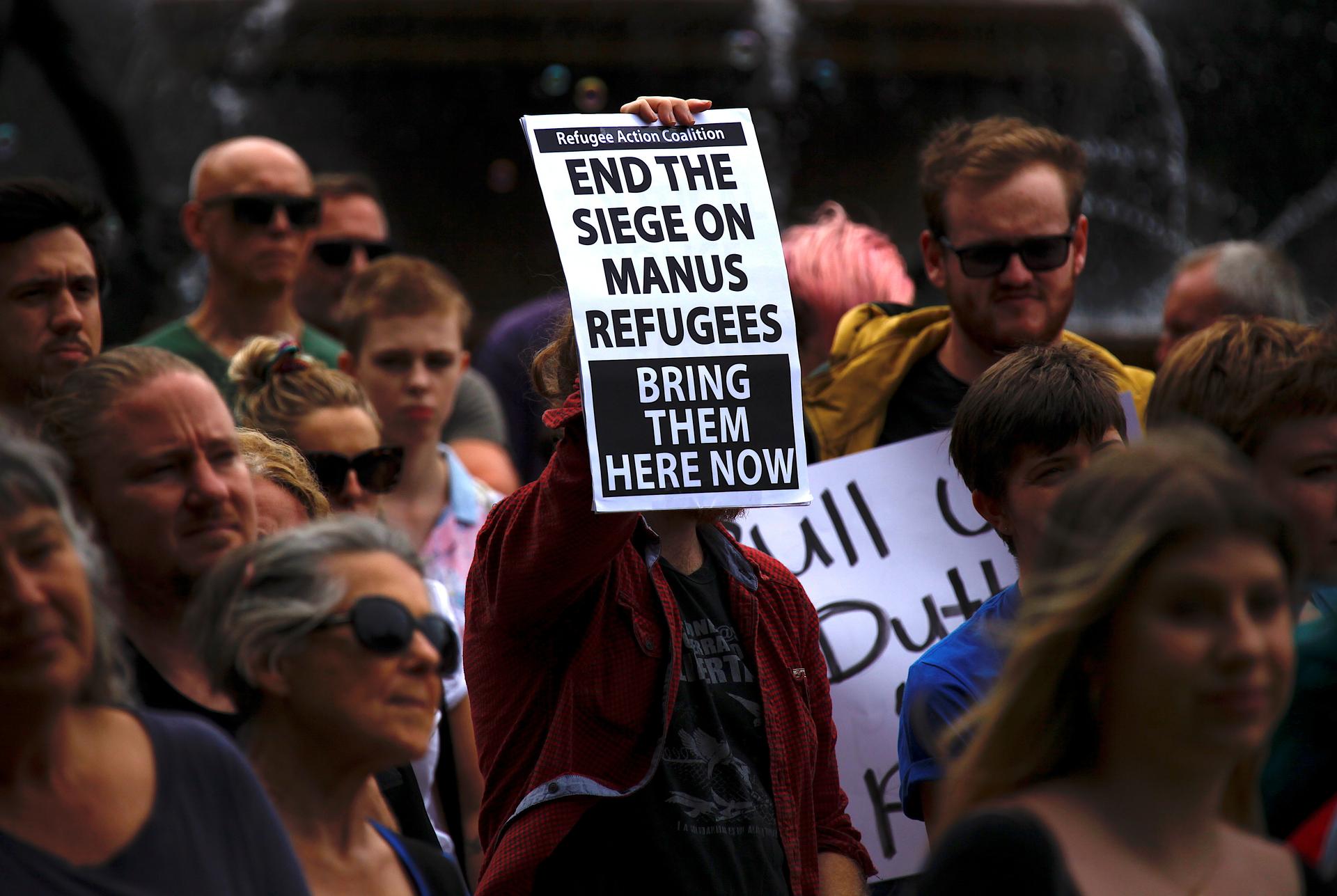 Refugee advocates hold placards as they participate in a protest in Sydney against the treatment of asylum-seekers at Australia-run detention centers