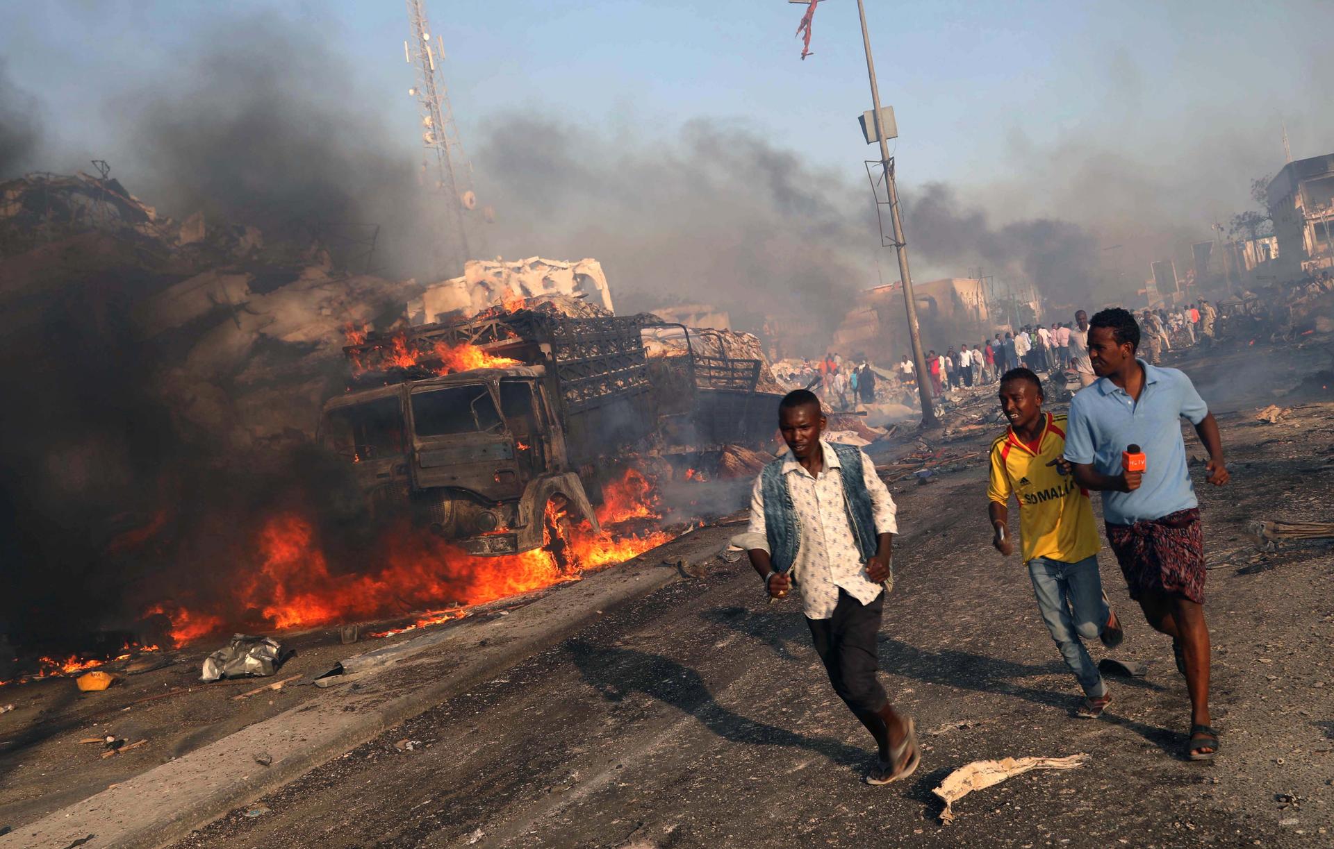 Civilians evacuate from the scene of an explosion in the Hodan district of Mogadishu, Somalia.
