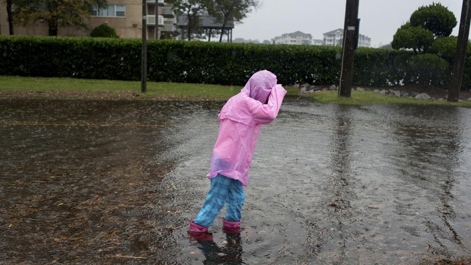 A child plays in the flooded streets of Norfolk, Virginia, during Hurricane Sandy in 2012. Norfolk is one of many coastal cities around the world experiencing more frequent flooding as sea levels rise in response to warmer global temperatures.