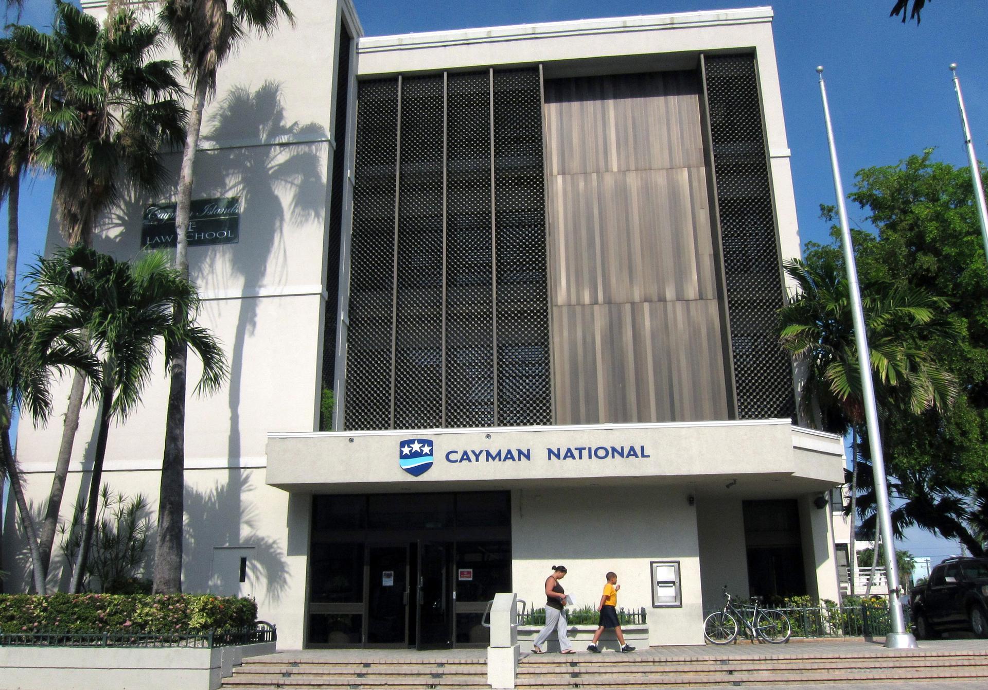 People walk out of a branch of the Cayman National Bank in George Town, Cayman Islands.