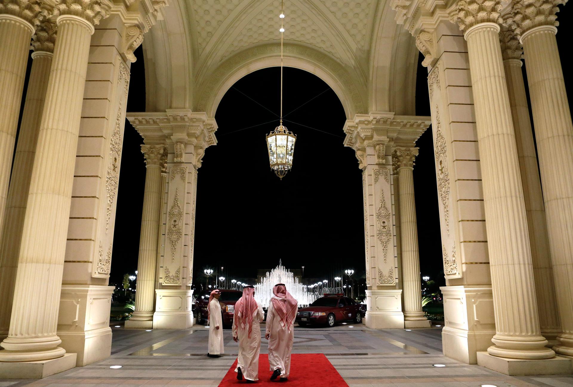 Saudi men walk at the entrance to the Ritz-Carlton Hotel, where U.S. Secretary of State John Kerry is staying in Riyadh March 4, 2013.
