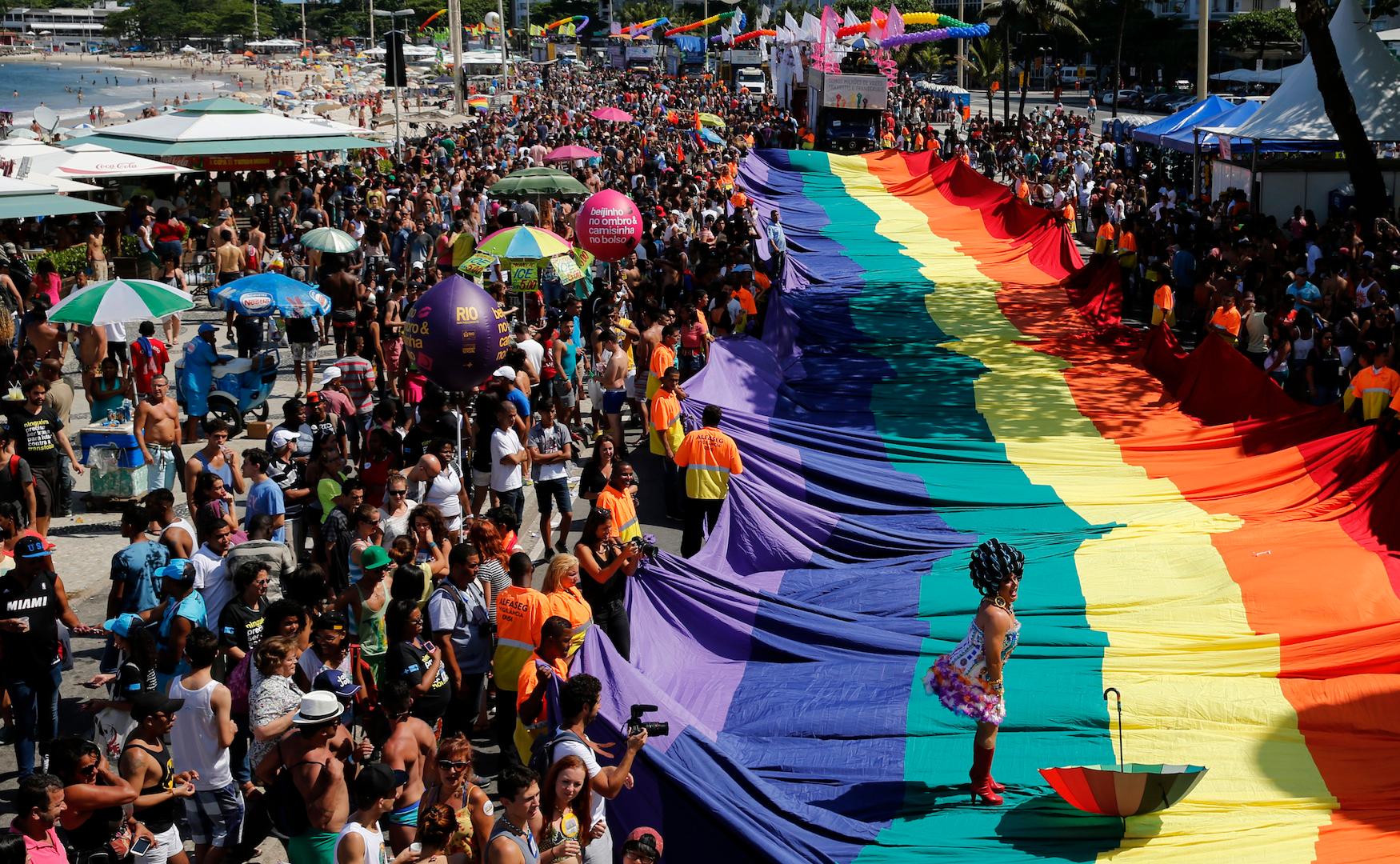 A participant performs on a giant rainbow flag during a Gay Pride Parade at Copacabana beach in Rio de Janeiro on Nov. 16, 2014.