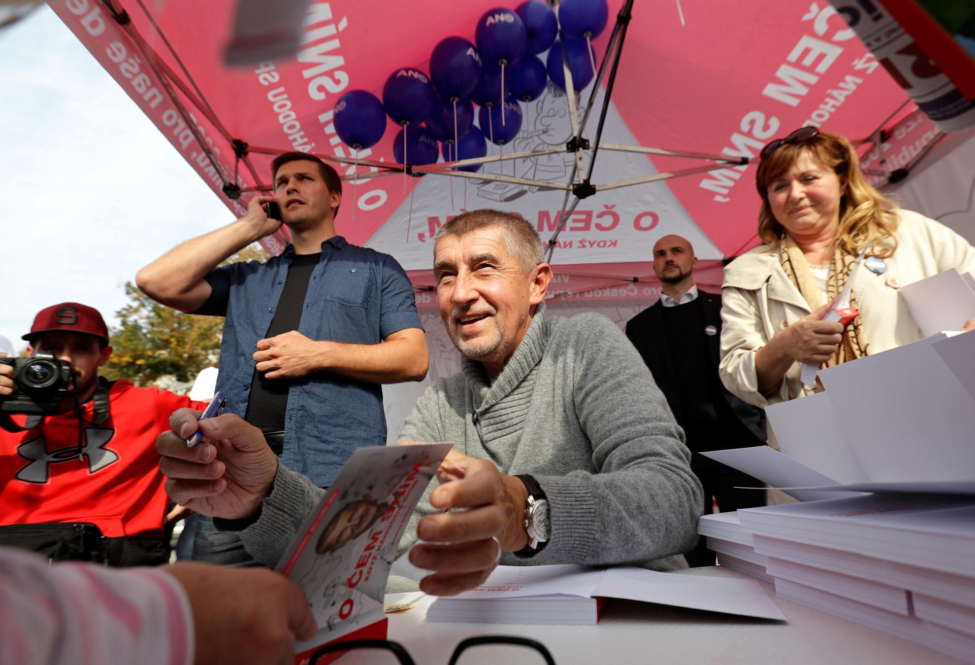 The leader of ANO party Andrej Babis signs books for a supporter during an election campaign rally in Prague, Czech Republic September 28, 2017. 