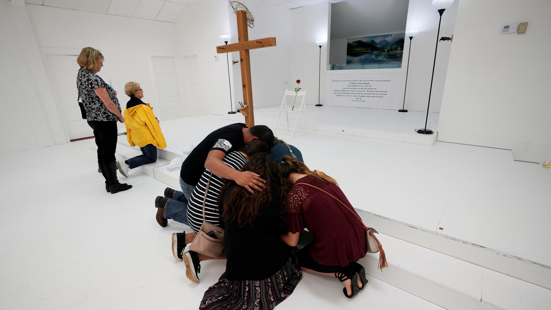 People pray in the First Baptist Church of Sutherland Springs where 26 people were killed in a shooting attack on November 5, 2017. The church was opened to the public as a memorial to those killed.